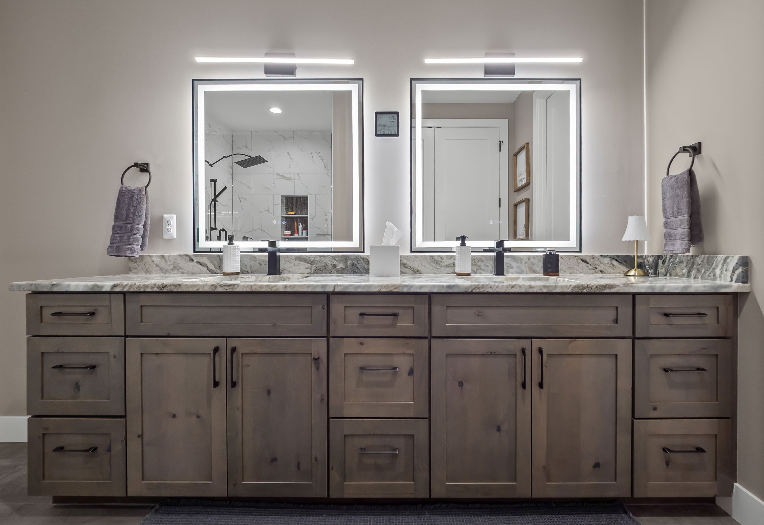 Oversized Rustic Alder double vanity, matte black faucets, and illuminated mirror lighting in the master bathroom.