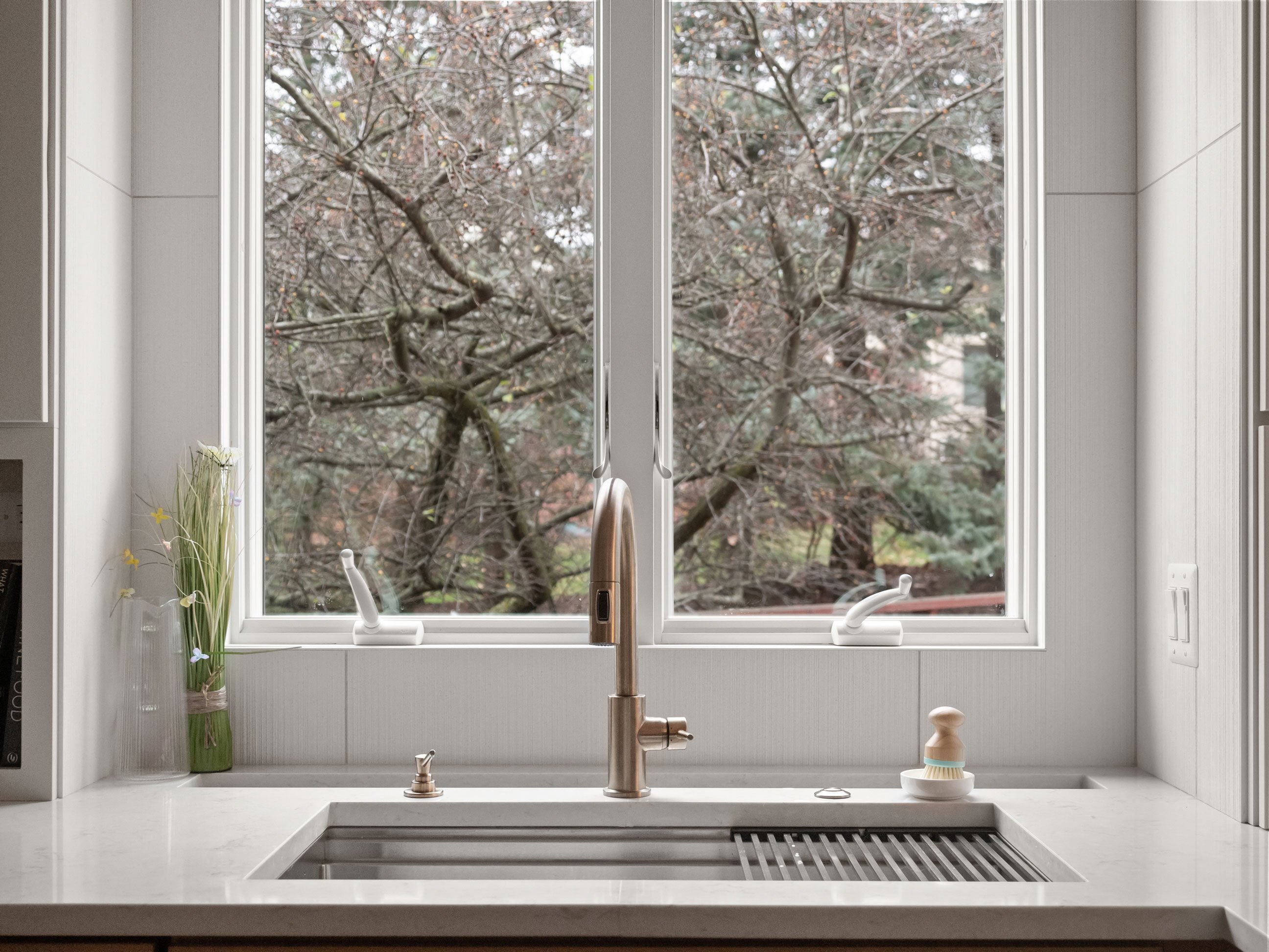 Workstation sink with integrated levels for drying racks, cutting boards, and strainers, with dish rack