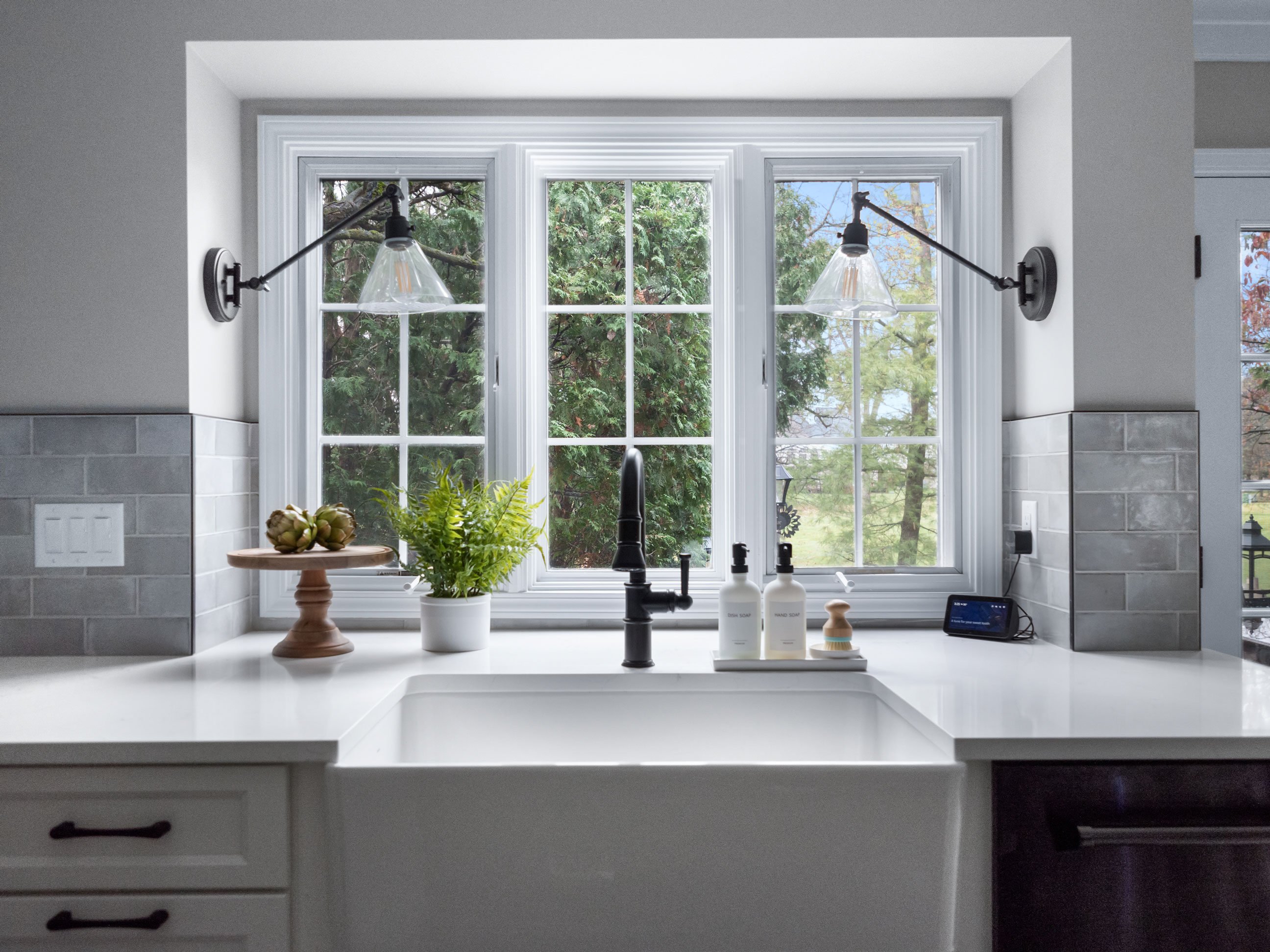 Medallion Cabinetry Wallace door style in Sea Salt White paint; Marazzi Rice tile in grey; farmhouse sink