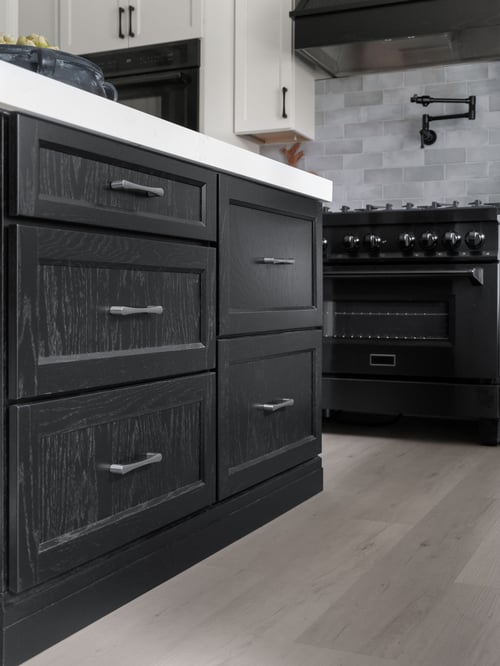 Medallion Cabinetry Wallace door style in Oak with Carriage Black paint; perimeter in Sea Salt White