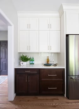 Merillat Masterpiece cabinetry in Sylvan door style, Cherry wood in Molasses stain and Maple wood painted Warm White.  Virginia Tile - Marazzi Zellige Gesso 4x4 Square [MRZZL1144] with sterling grout and a Jolly Schluter trim in white PVC.