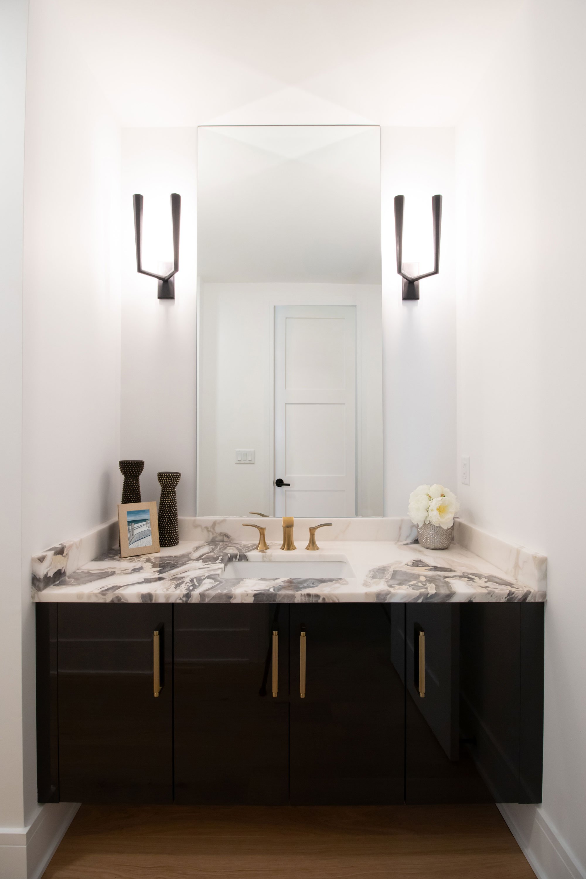 Powder bath featuring Inspira Cabinetry in the Vienna door style in Onyx with high gloss Wired Zinc finish