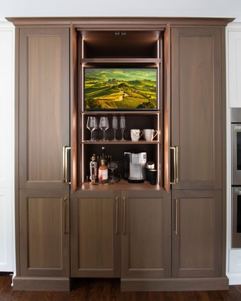 Pocket doors reveal a bar and TV on the fridge wall