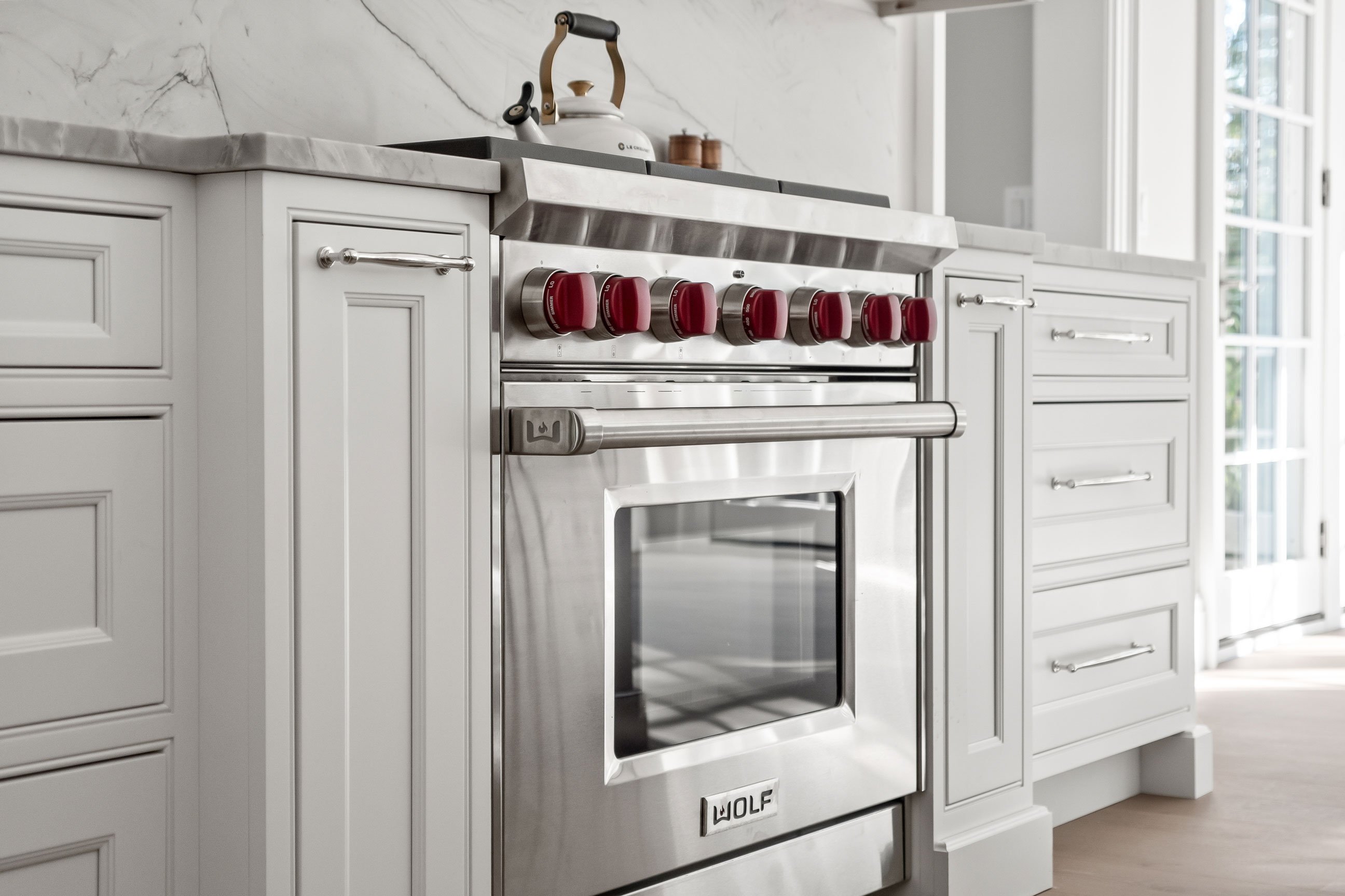 Wolf range in white transitional kitchen featuring inset cabinetry.