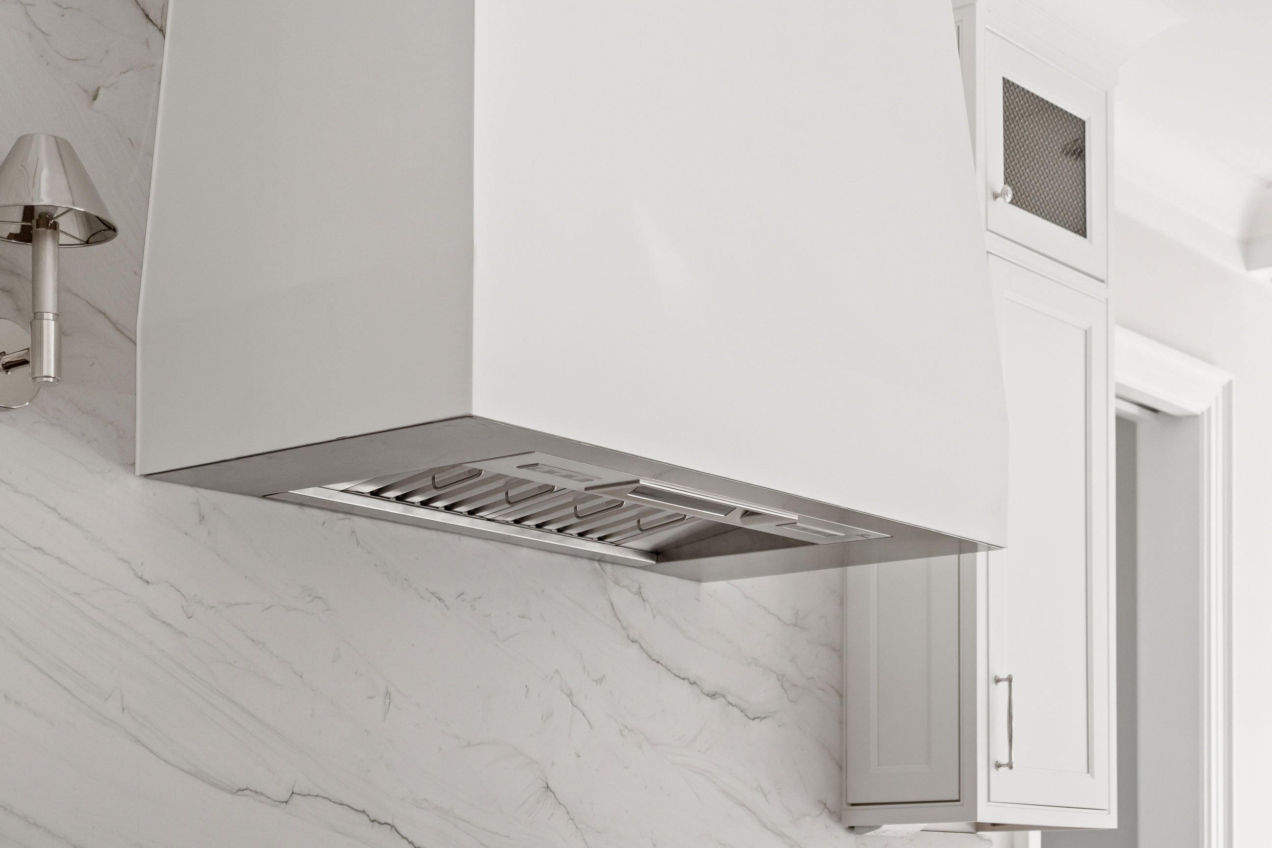 Custom white drywall hood about the range in a transitional kitchen
