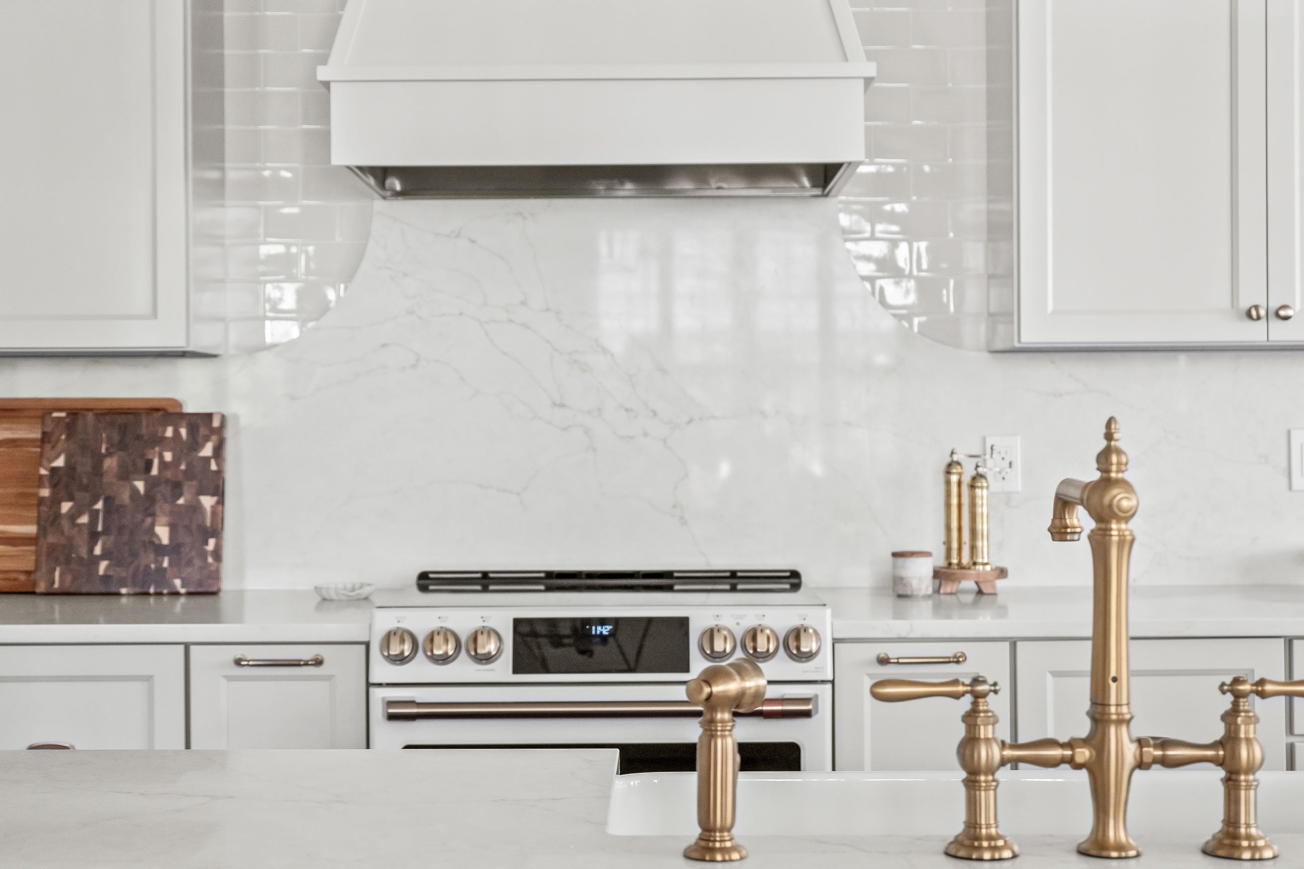 Full height quartz backsplash with tile on range wall of kitchen