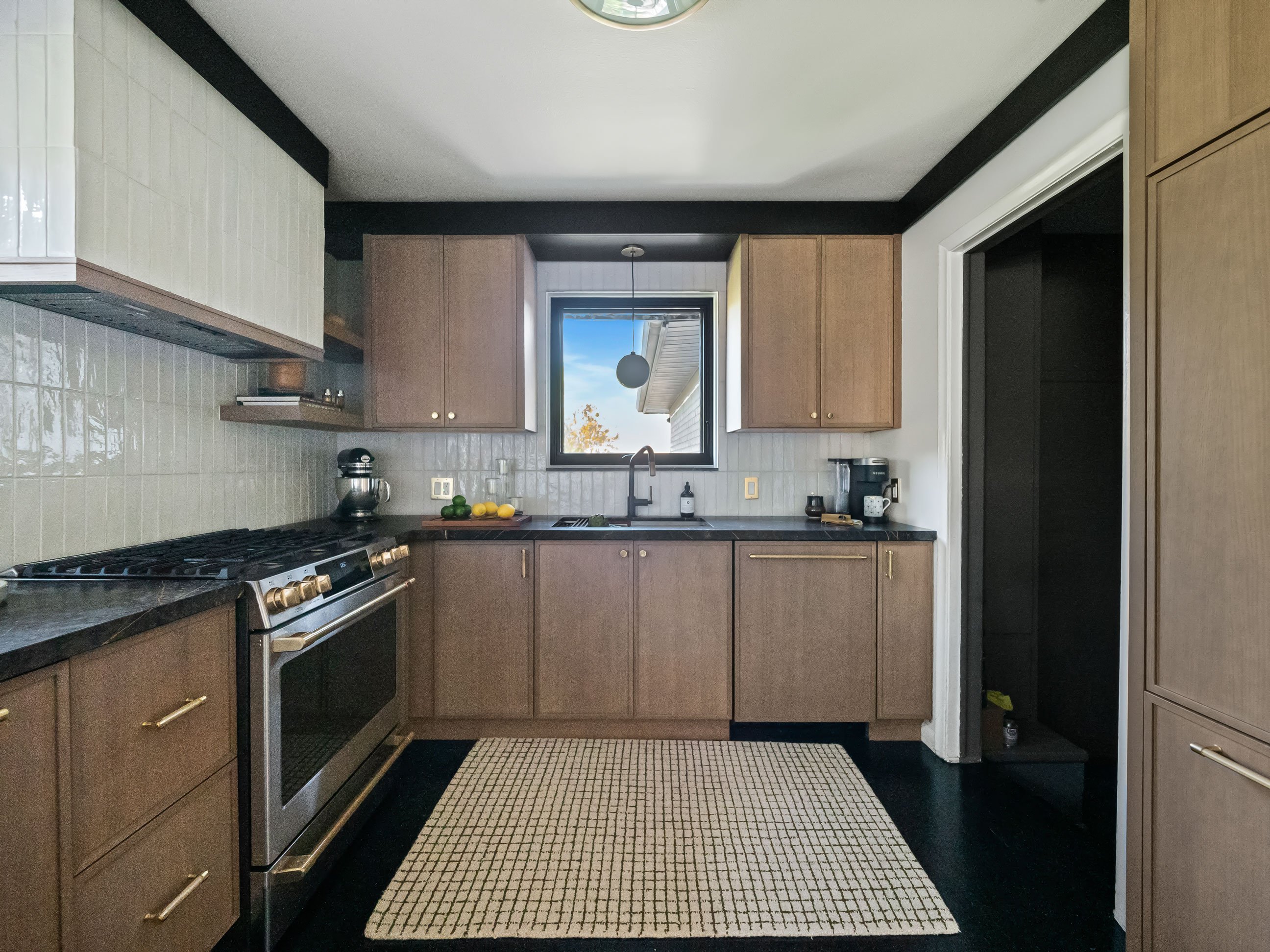 Kitchen featuring stained cabinetry and dark countertops