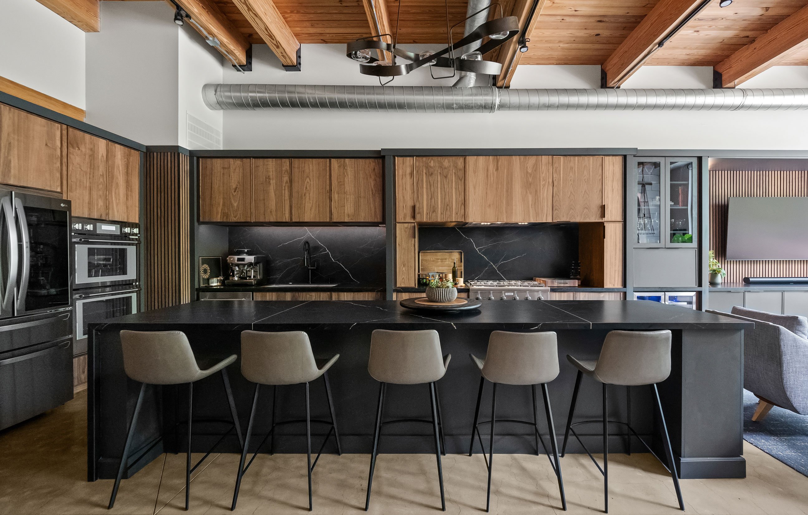 Dramatic loft kitchen featuring walnut and dark gray cabinetry