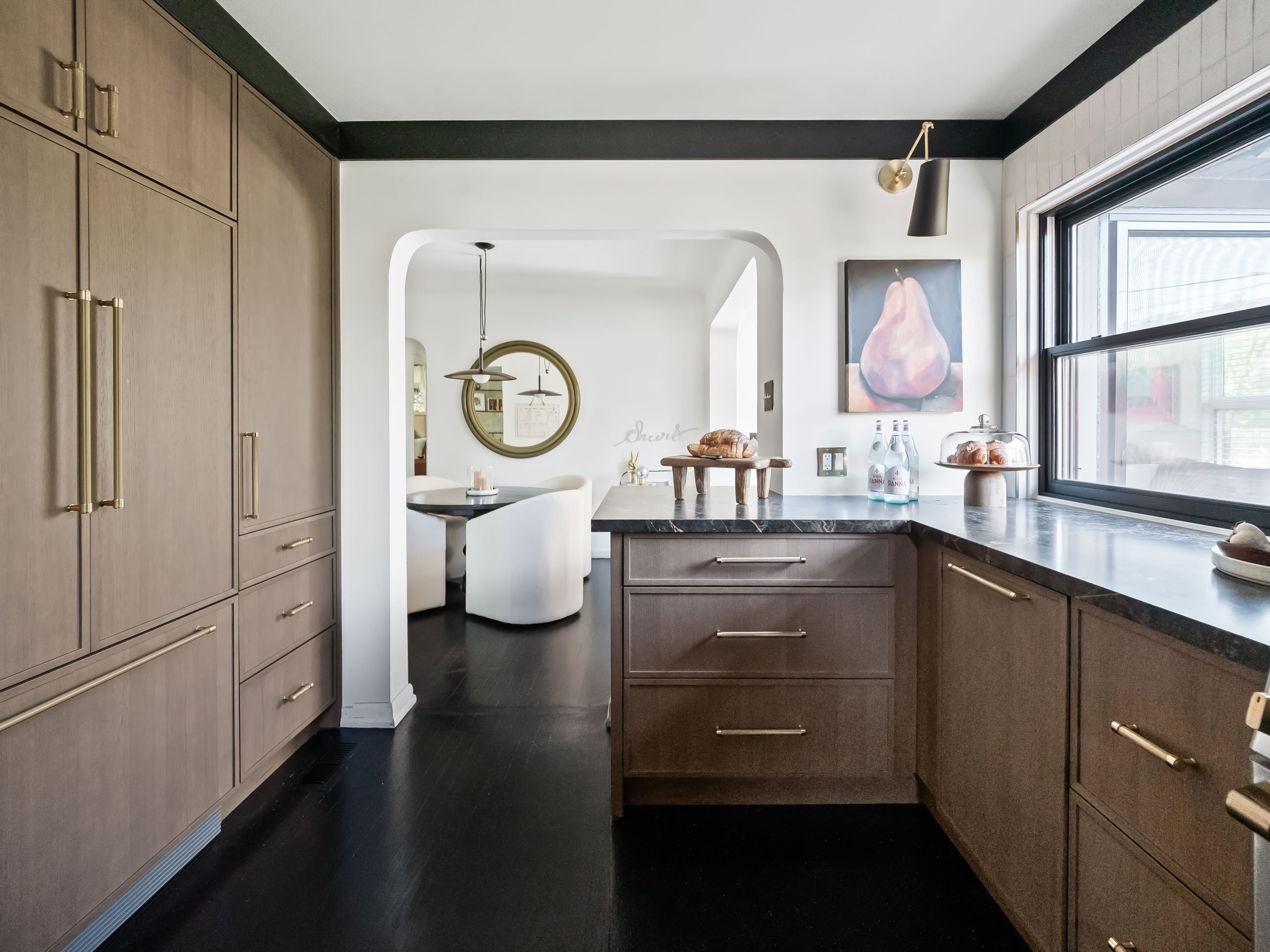Moody meets Bright with black floors, countertops and trim contrasting bright tile and warm wood cabinetry