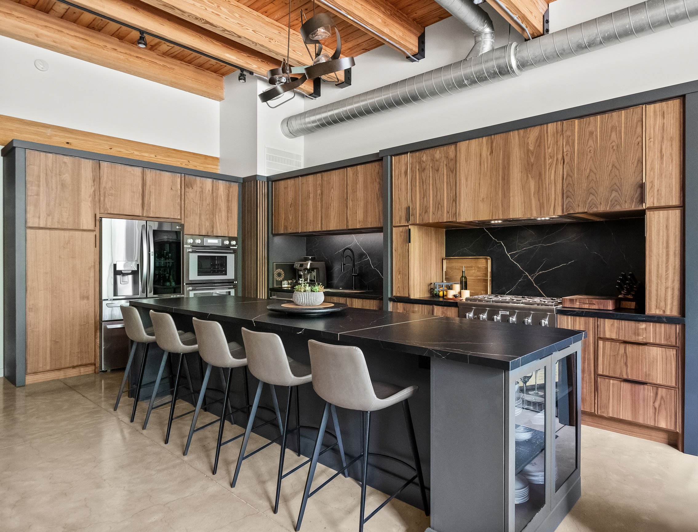 Contemporary loft kitchen featuring natural walnut and black-painted Inspira Cabinetry