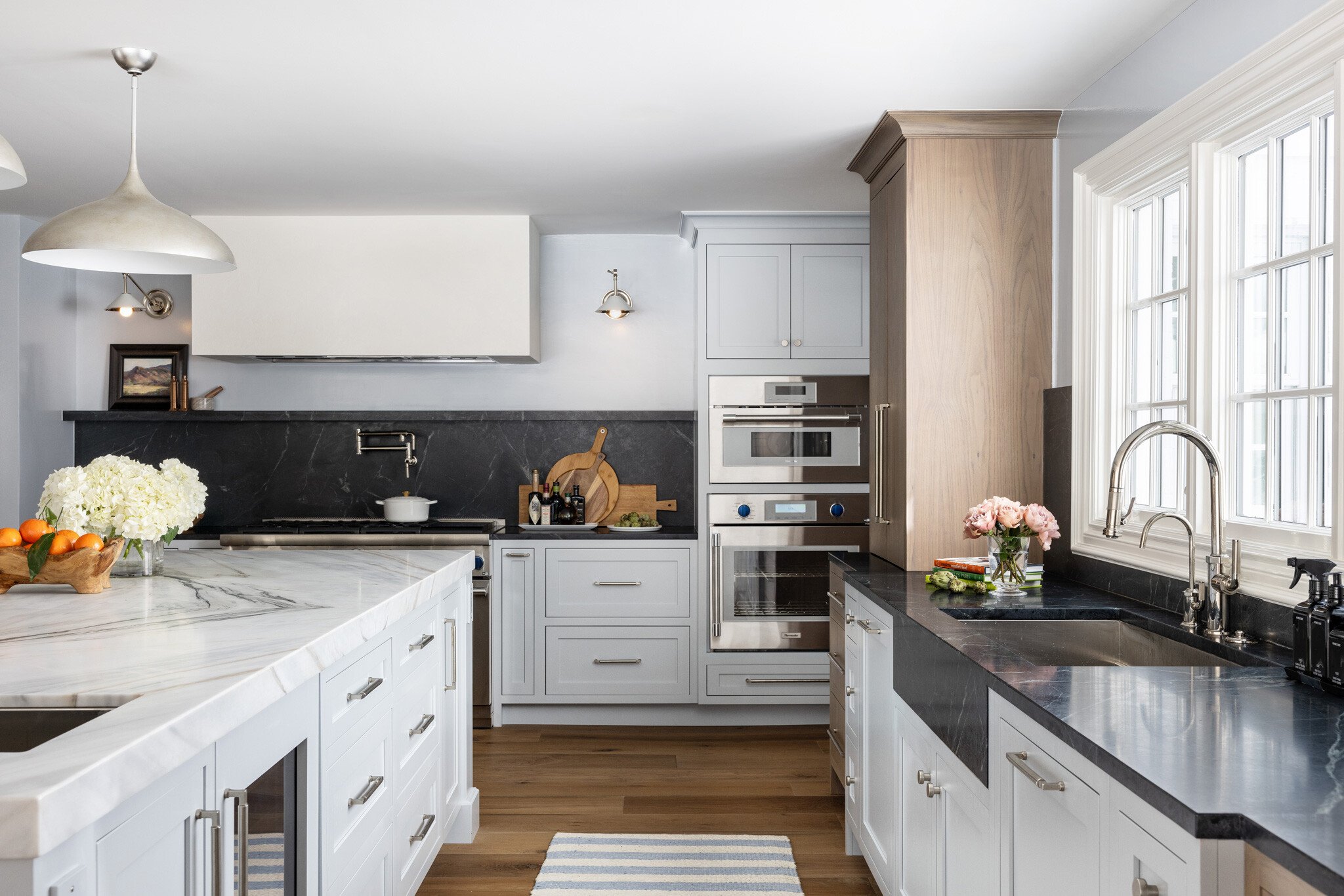 Soft, airy blue mixes with touches of walnut and soapstone in this kitchen remodel