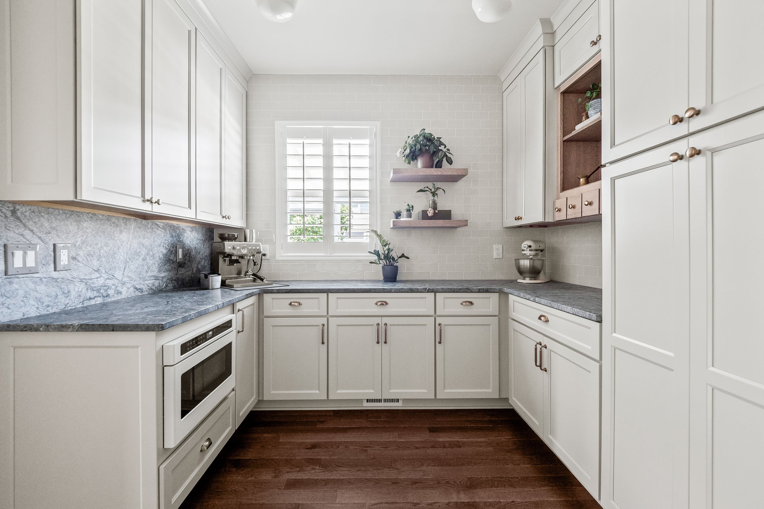 Pantry extension with soapstone countertops, open shelving, and additional storage cabinetry.