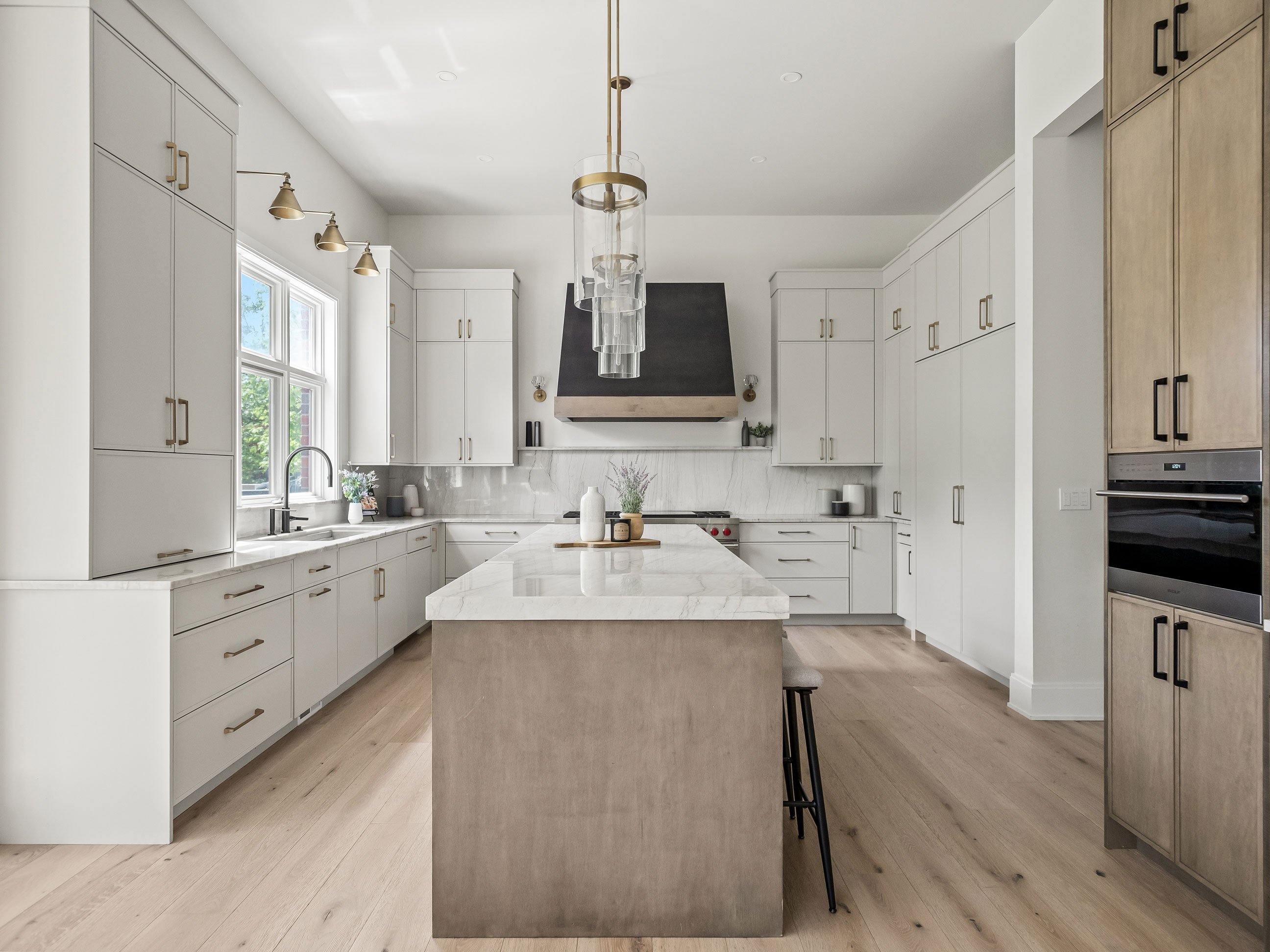 Clean-lined kitchen remodel with white and light stained cabinetry