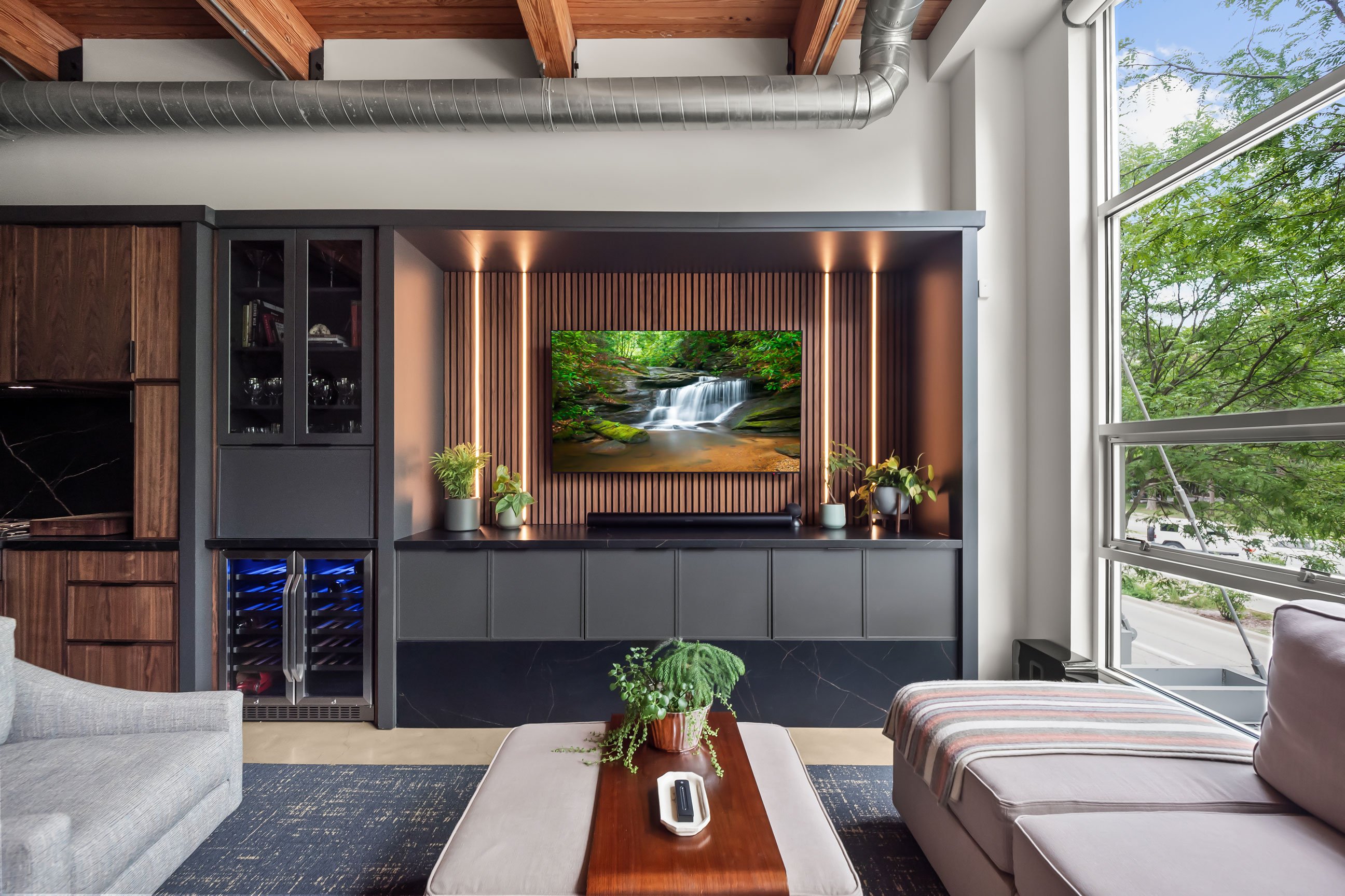 Contemporary loft entertainment area featuring natural walnut and black-painted Inspira Cabinetry