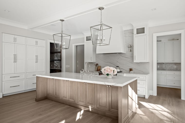 Bright transitional kitchen with soft white inset cabinets, warm wood island, and panel-ready appliances designed by KSI.