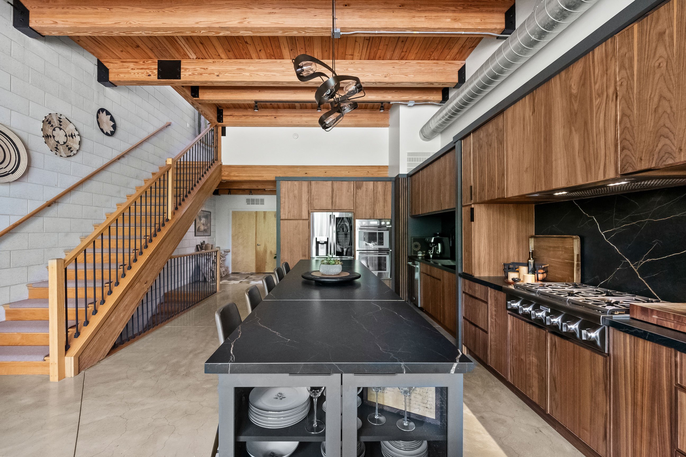 Contemporary loft kitchen featuring natural walnut and black-painted Inspira Cabinetry