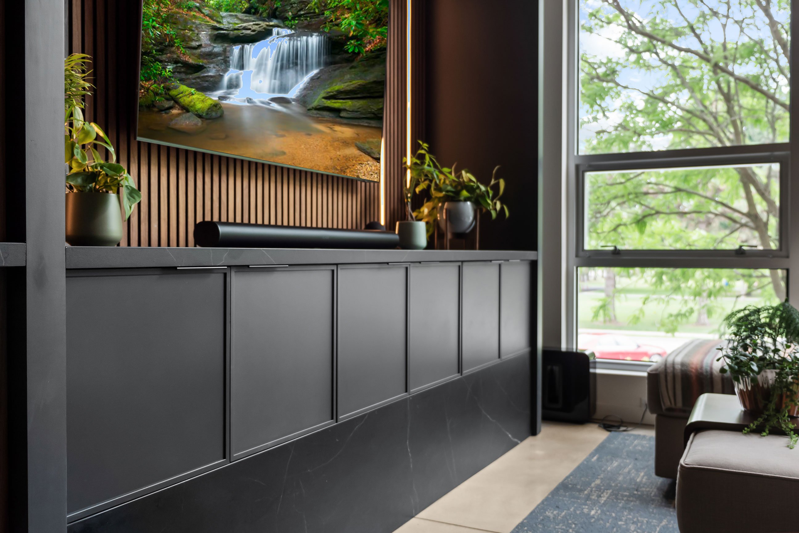 Contemporary loft entertainment area featuring natural walnut and black-painted Inspira Cabinetry