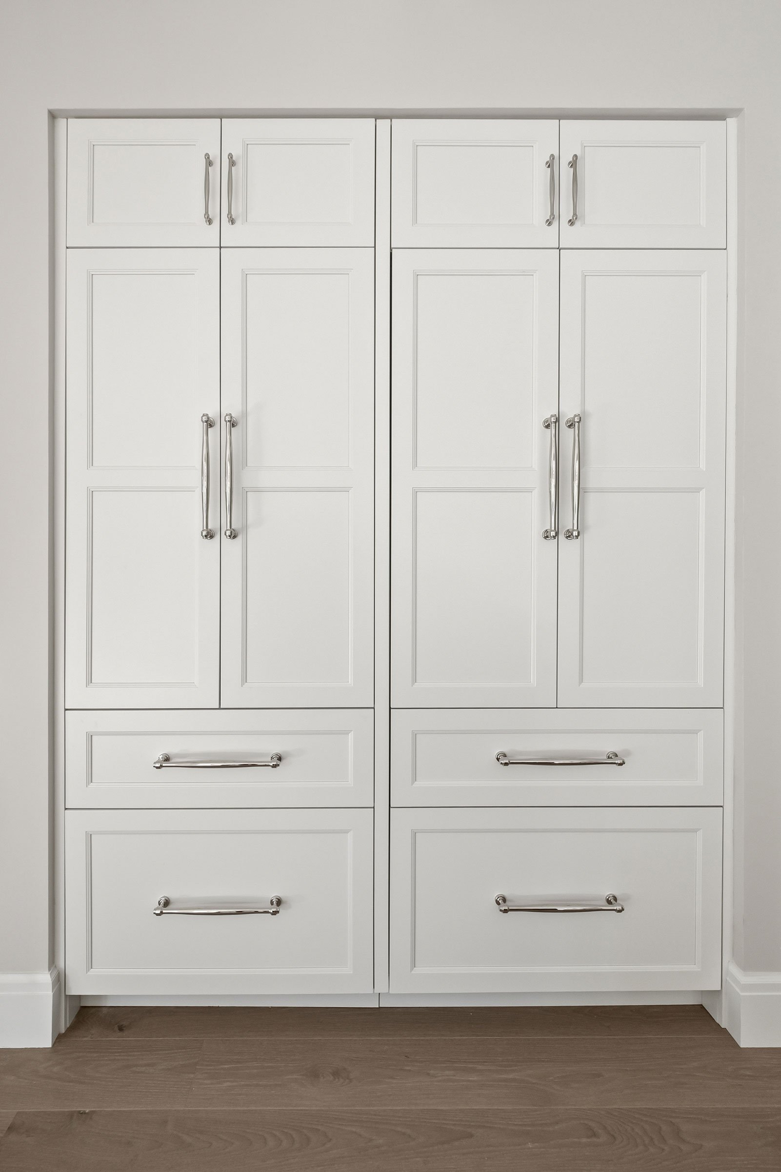 Custom panel-ready refrigerator wall designed to resemble furniture, with inset cabinetry and integrated storage designed by KSI Kitchen & Bath.