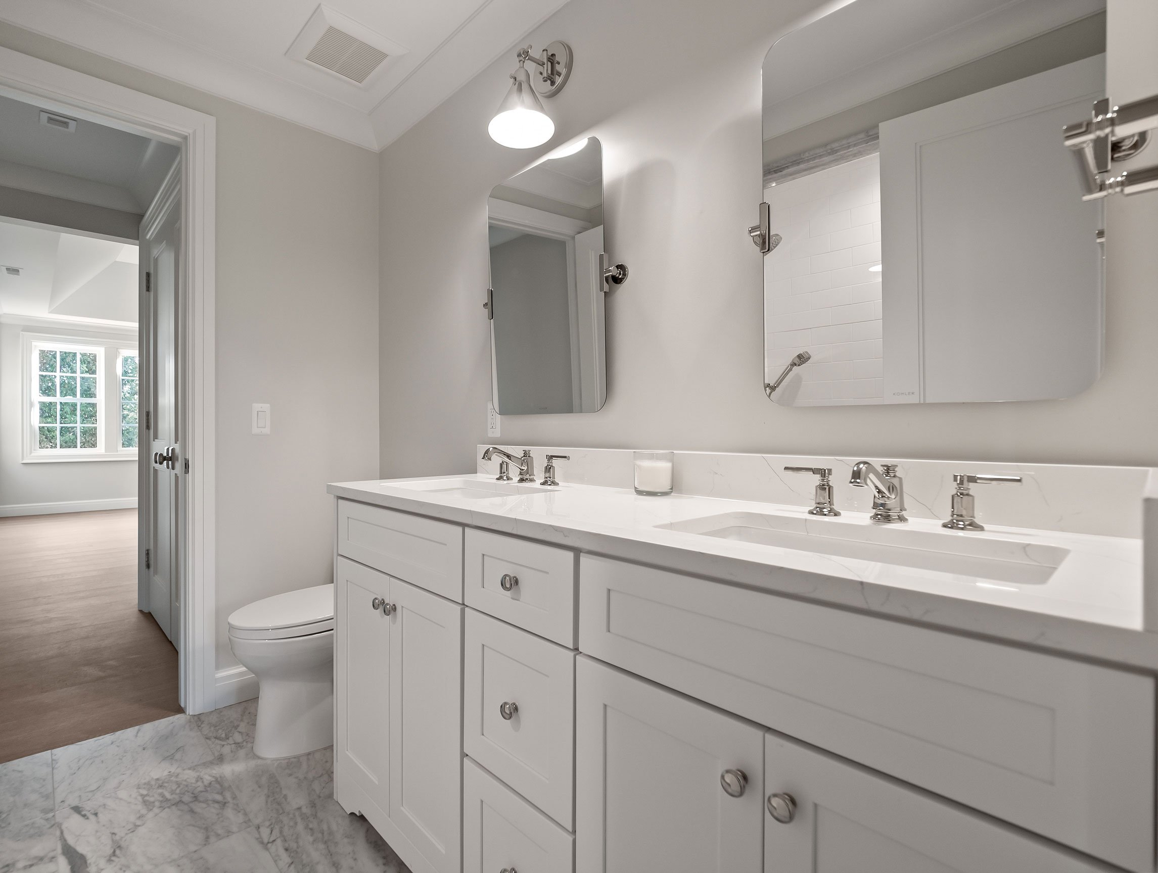 Secondary bath featuring pass-through Jack and Jill layout in a neutral white palette.