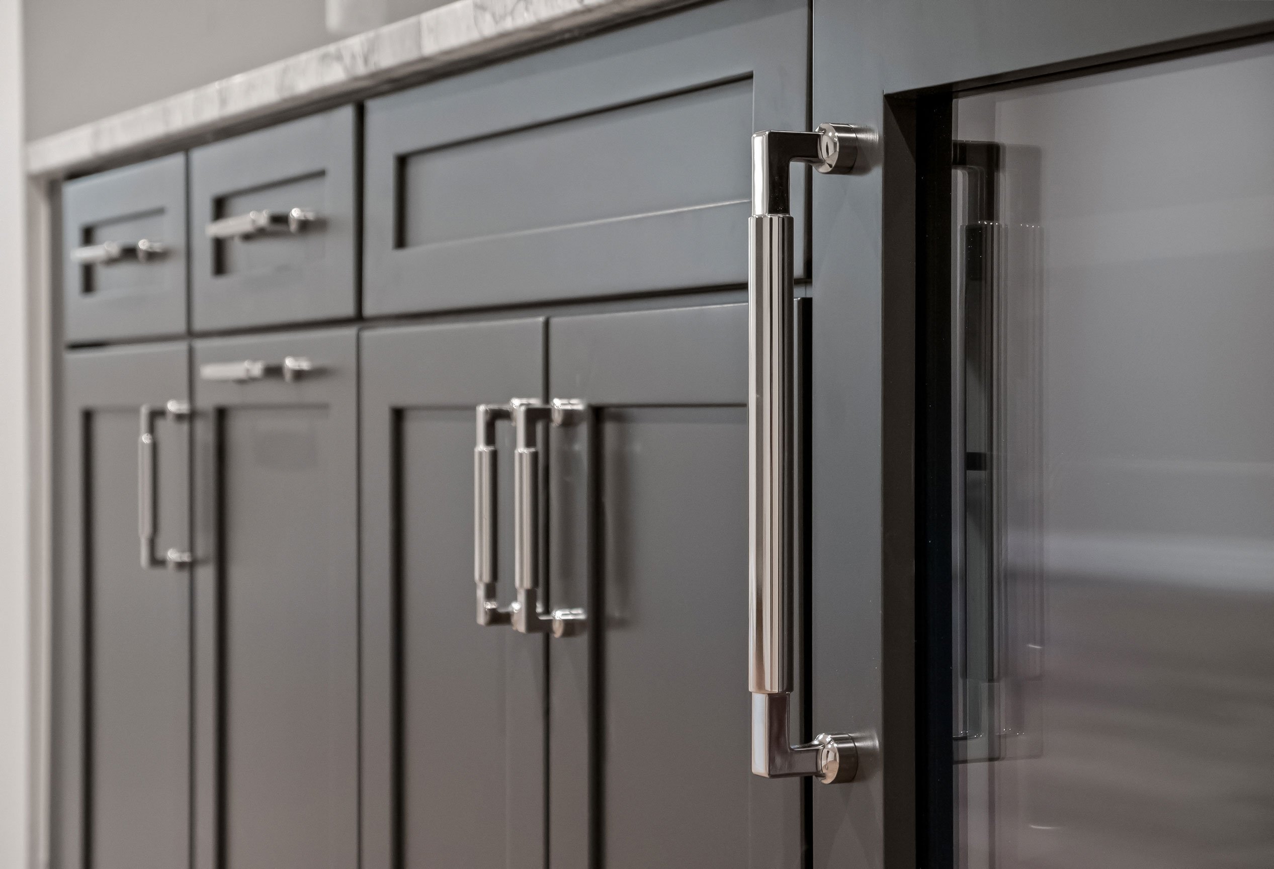 Detail of dark shaker cabinetry in the basement bar.