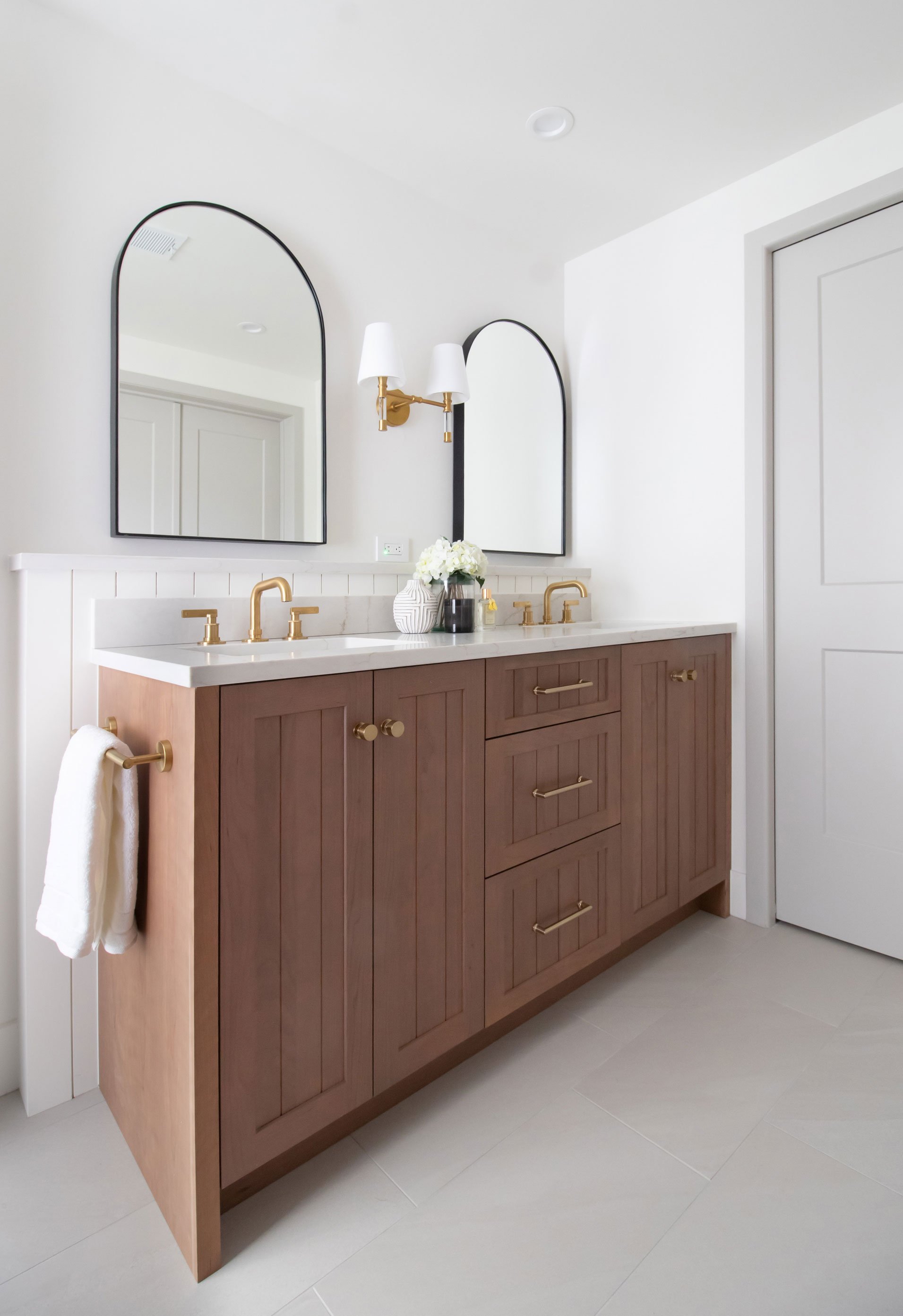 Master bath dual vanity featuring warm wood cabinetry