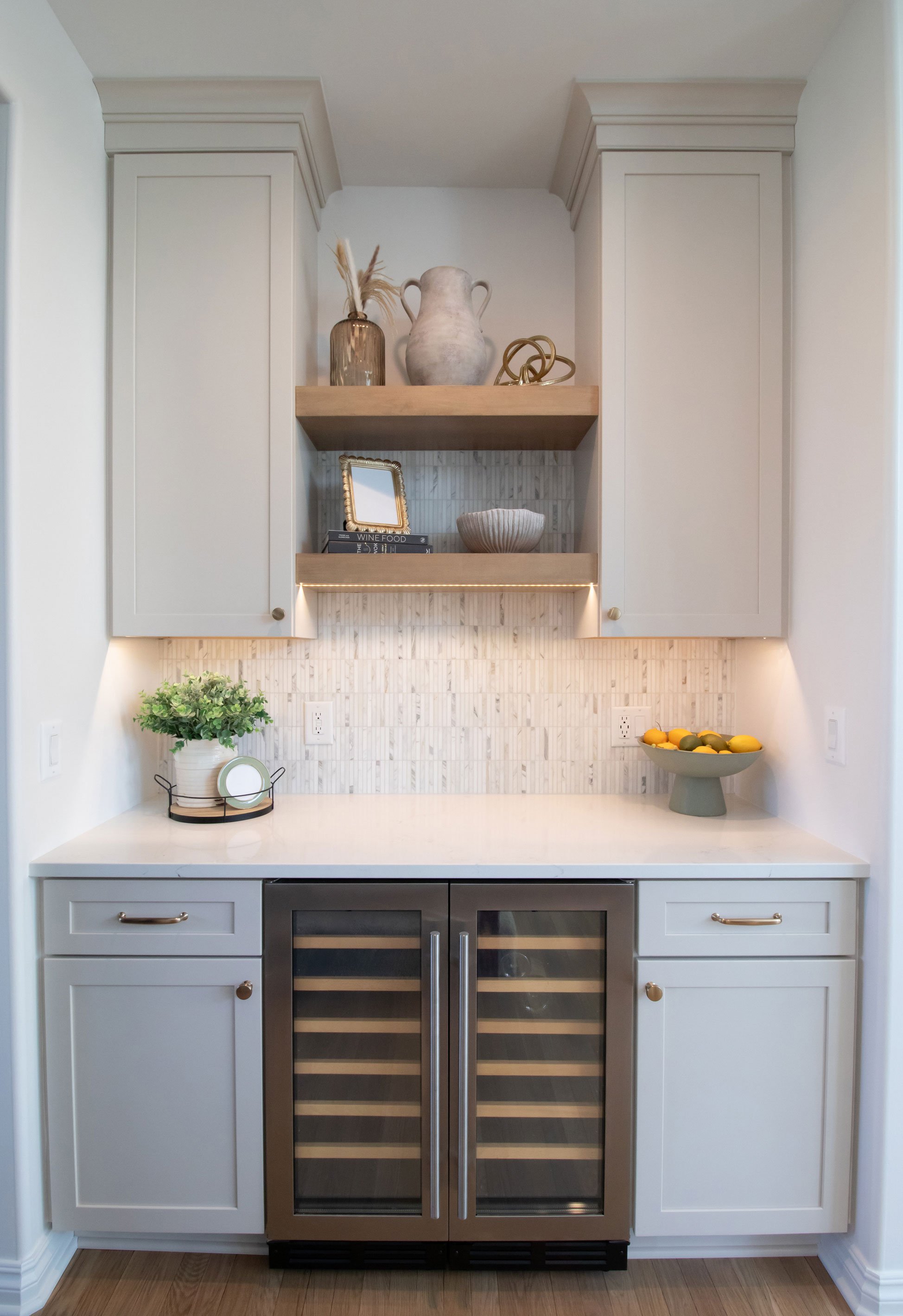Cabinetry: Merillat Masterpiece Martel Door in Cottage Paint; Countertops: French Lace Quartz; Tile: Artistic Tile Abbey Road Calacatta Gold Marble Mosaic, honed