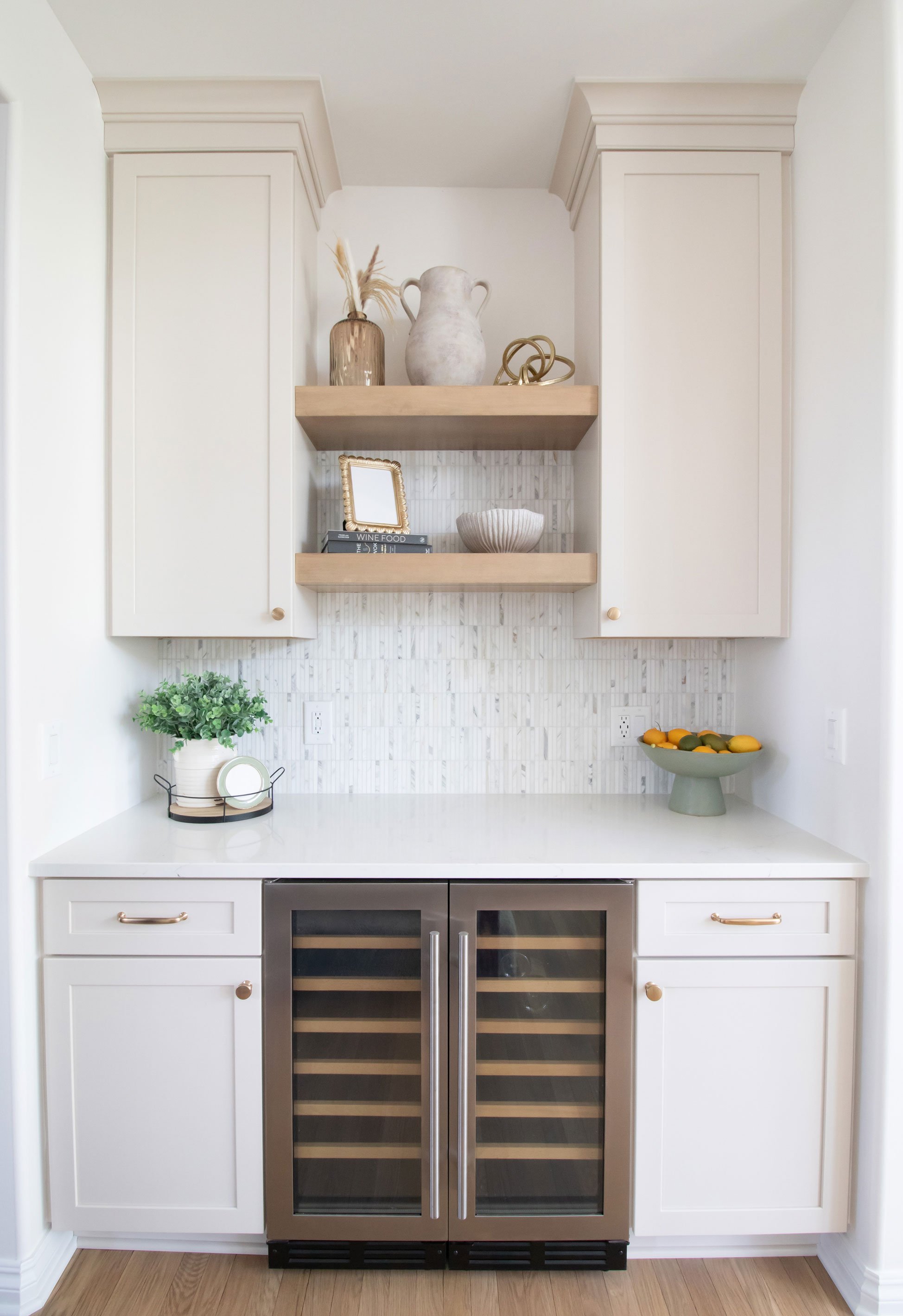 Cabinetry: Merillat Masterpiece Martel Door in Cottage Paint; Countertops: French Lace Quartz; Tile: Artistic Tile Abbey Road Calacatta Gold Marble Mosaic, honed