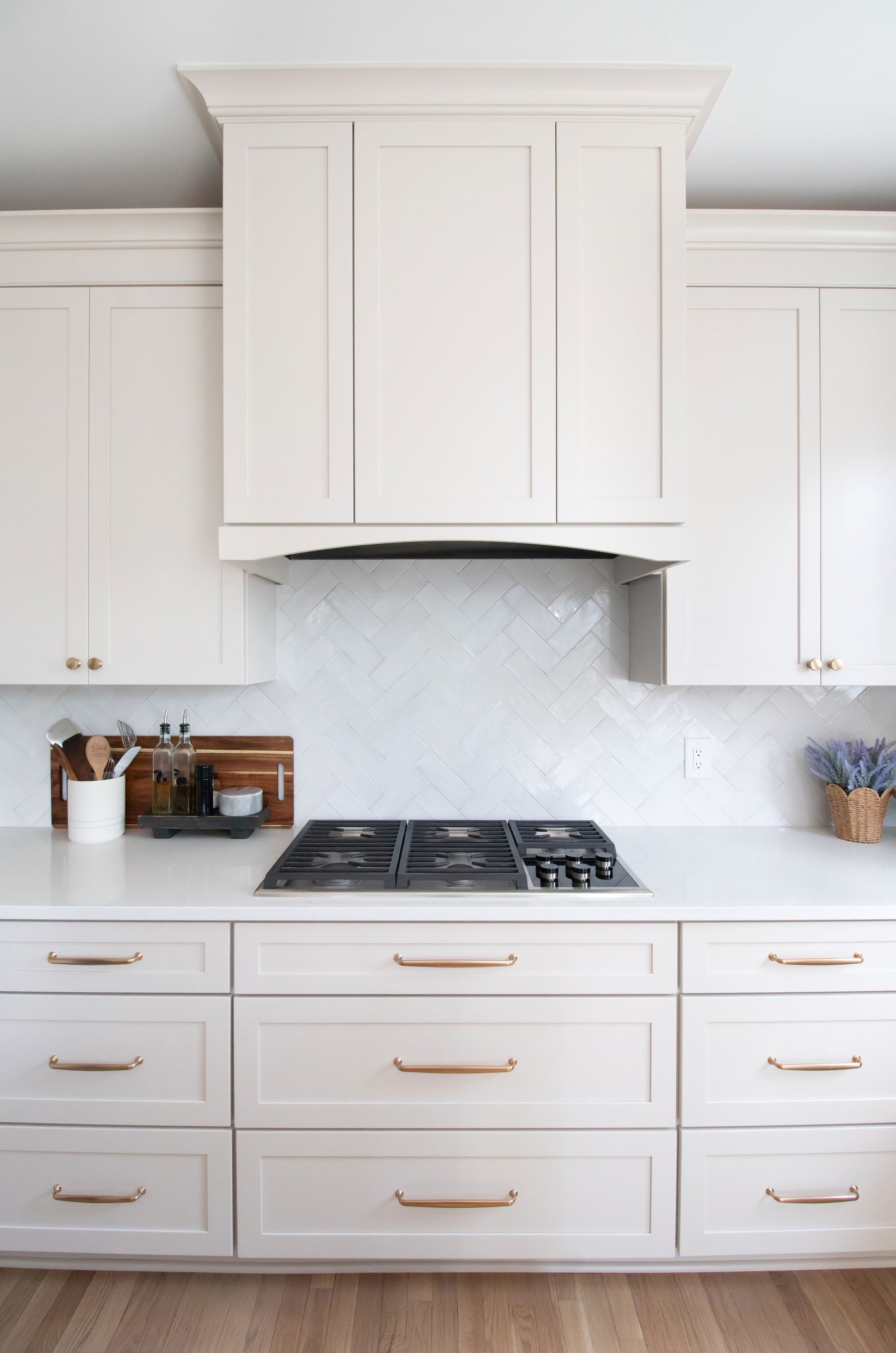 Cabinetry: Merillat Masterpiece Martel Door in Cottage Paint; Countertops: French Lace Quartz; Tile: Marazzi Rice Bianco 3x8 in herringbone pattern