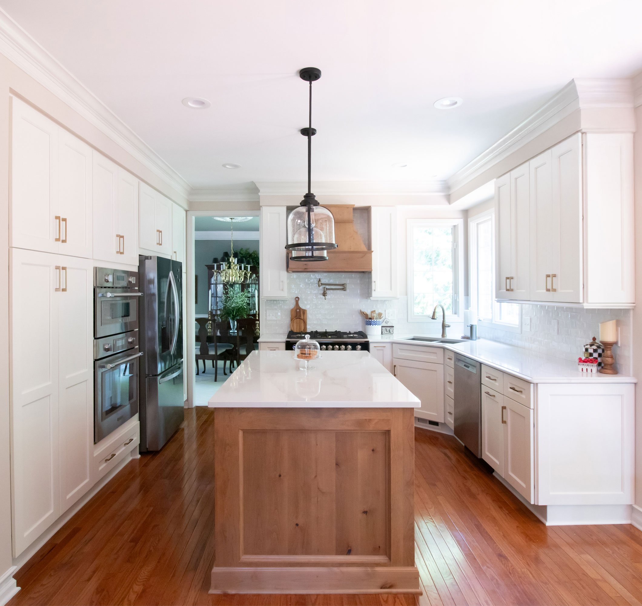 Transitional French Country style kitchen with blend of white and hickory cabinets and white countertops