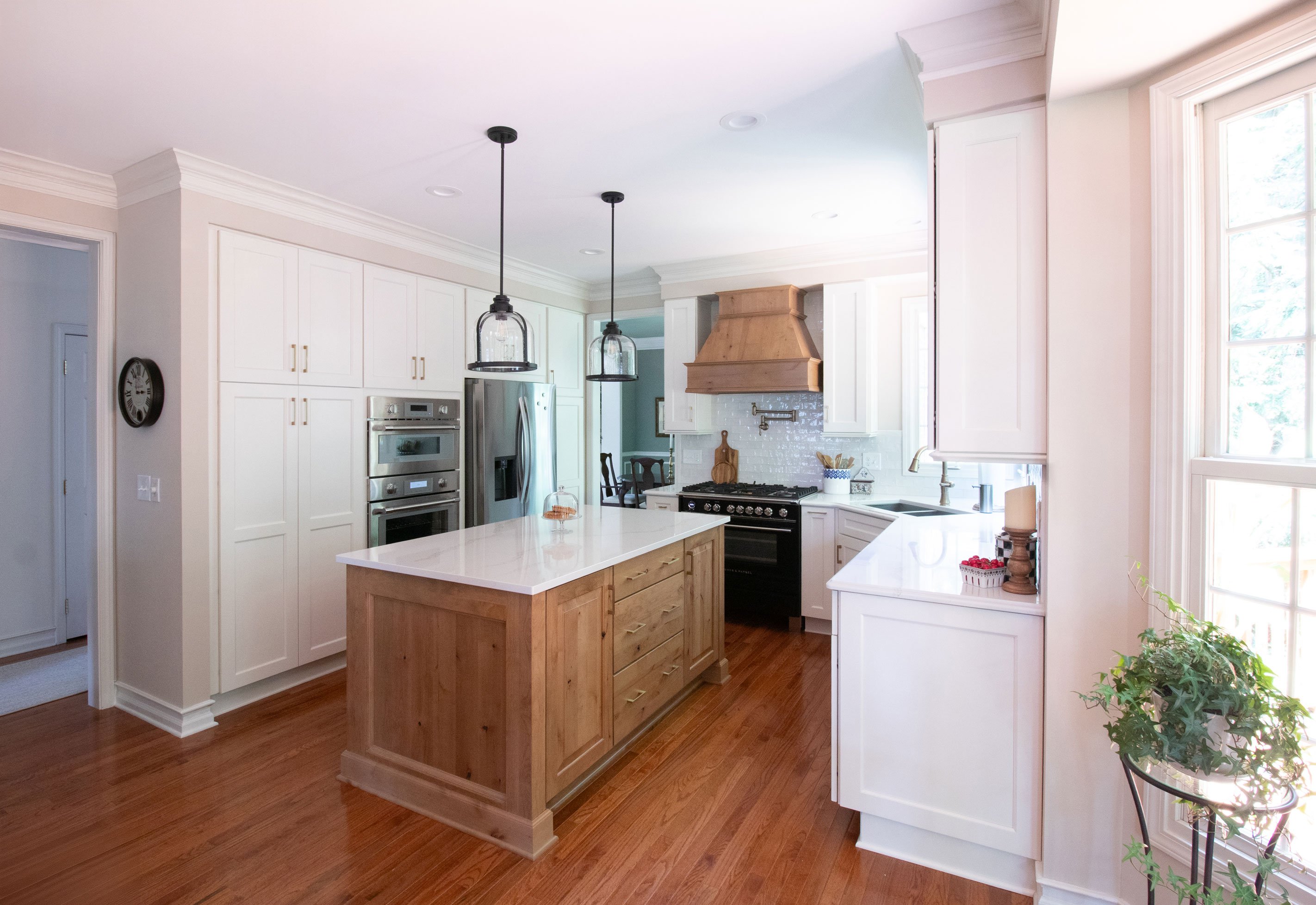 Transitional French Country style kitchen with blend of white and hickory cabinets and white countertops