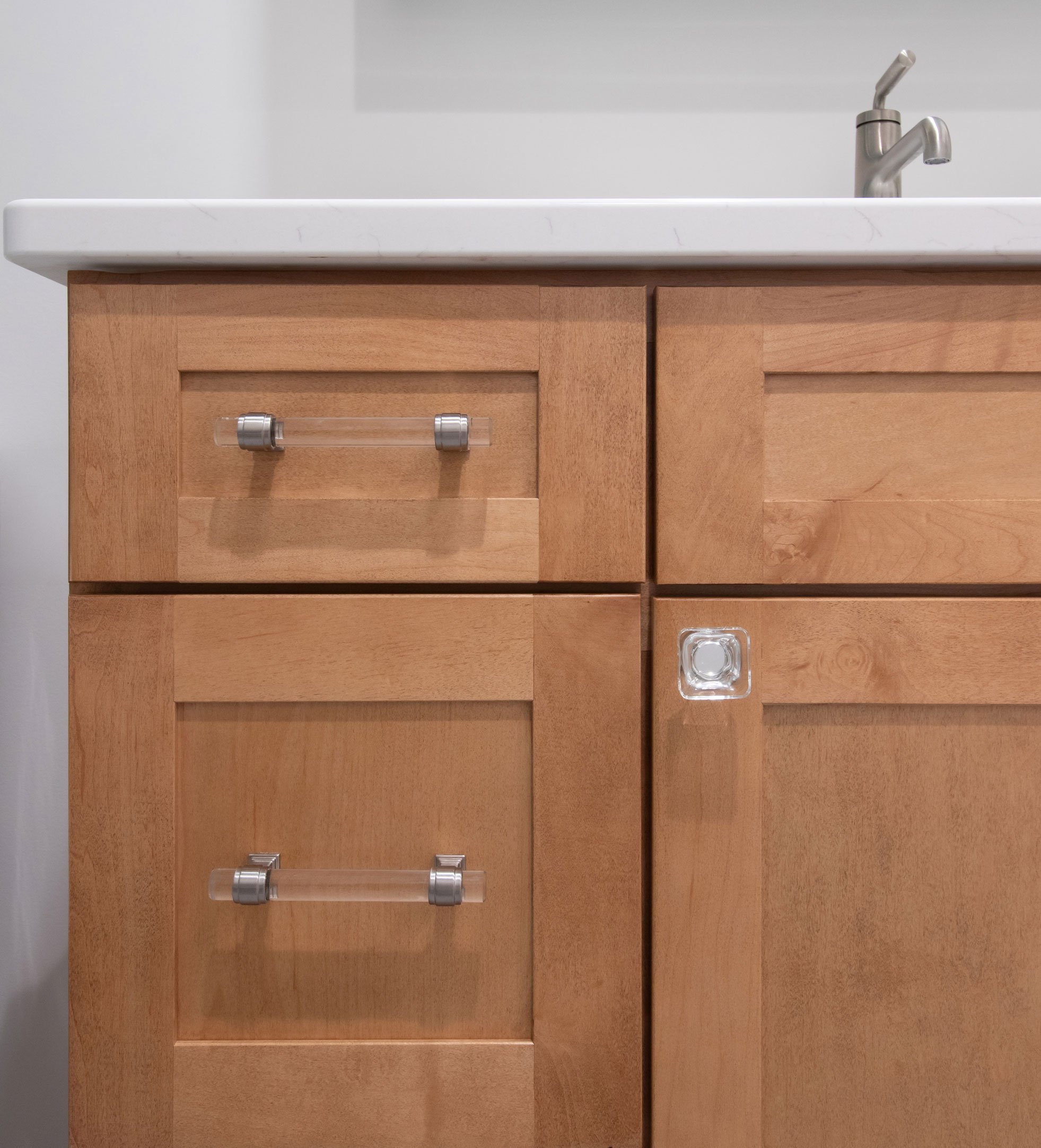 Bath vanity with warm wood shaker cabinetry, Amerock designer hardware and quartz top