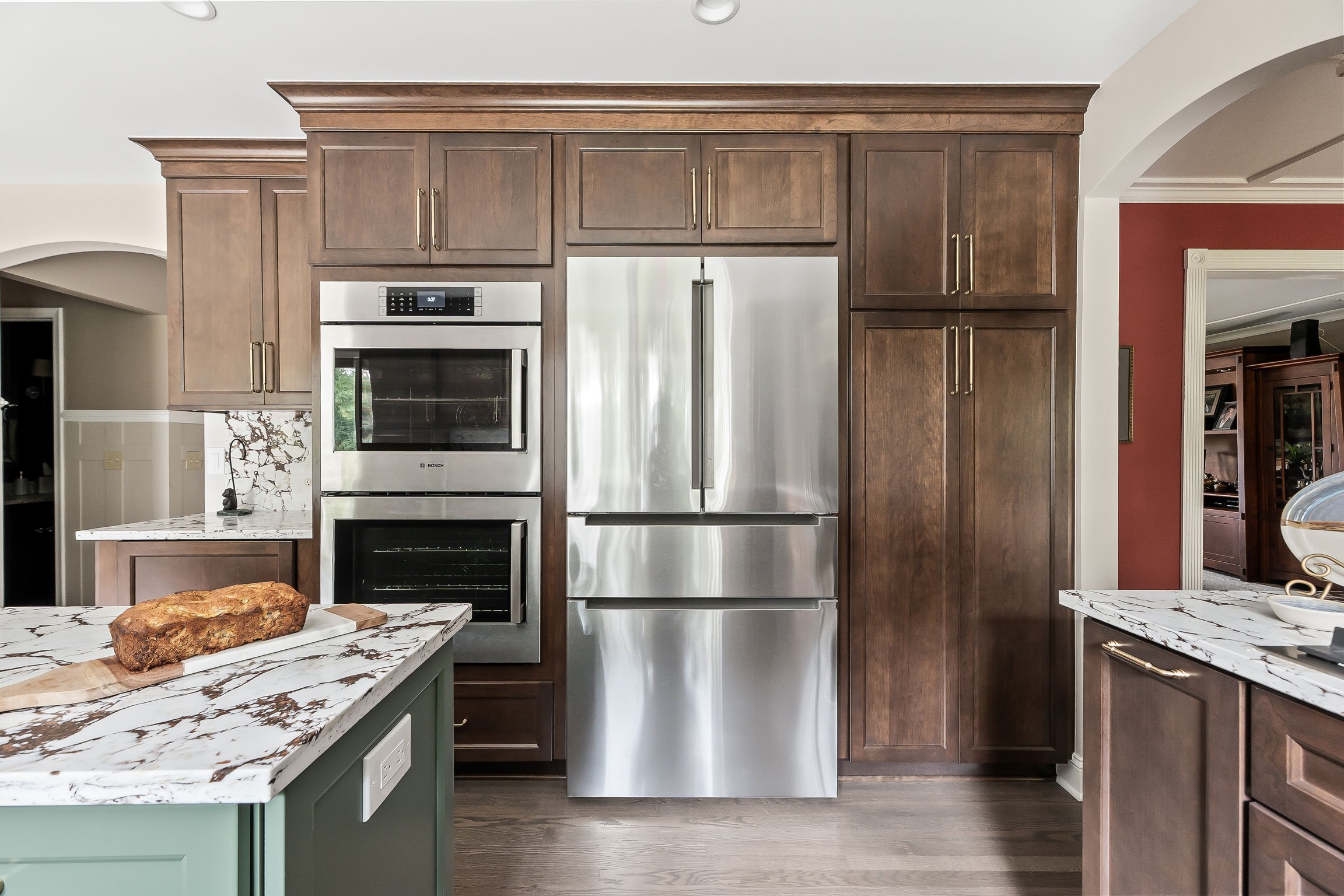 The refrigerator and wall oven cabinetry wall, built with cherry cabinetry in a Brown Sugar finish and stainless Bosch appliances.