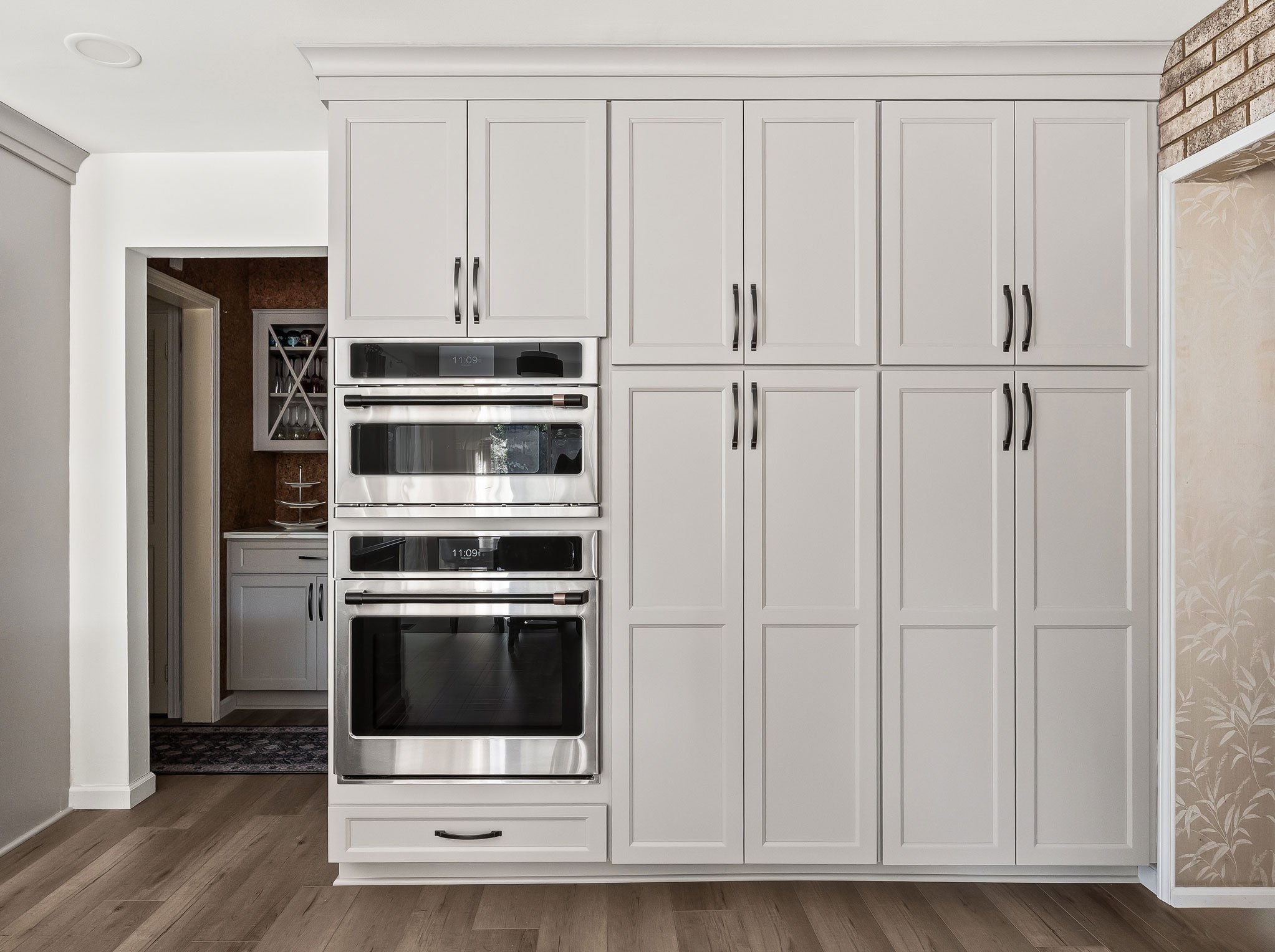 A floor-to-ceiling pantry wall with a built-in Café double wall oven and microwave, flanked by full-height storage cabinets.