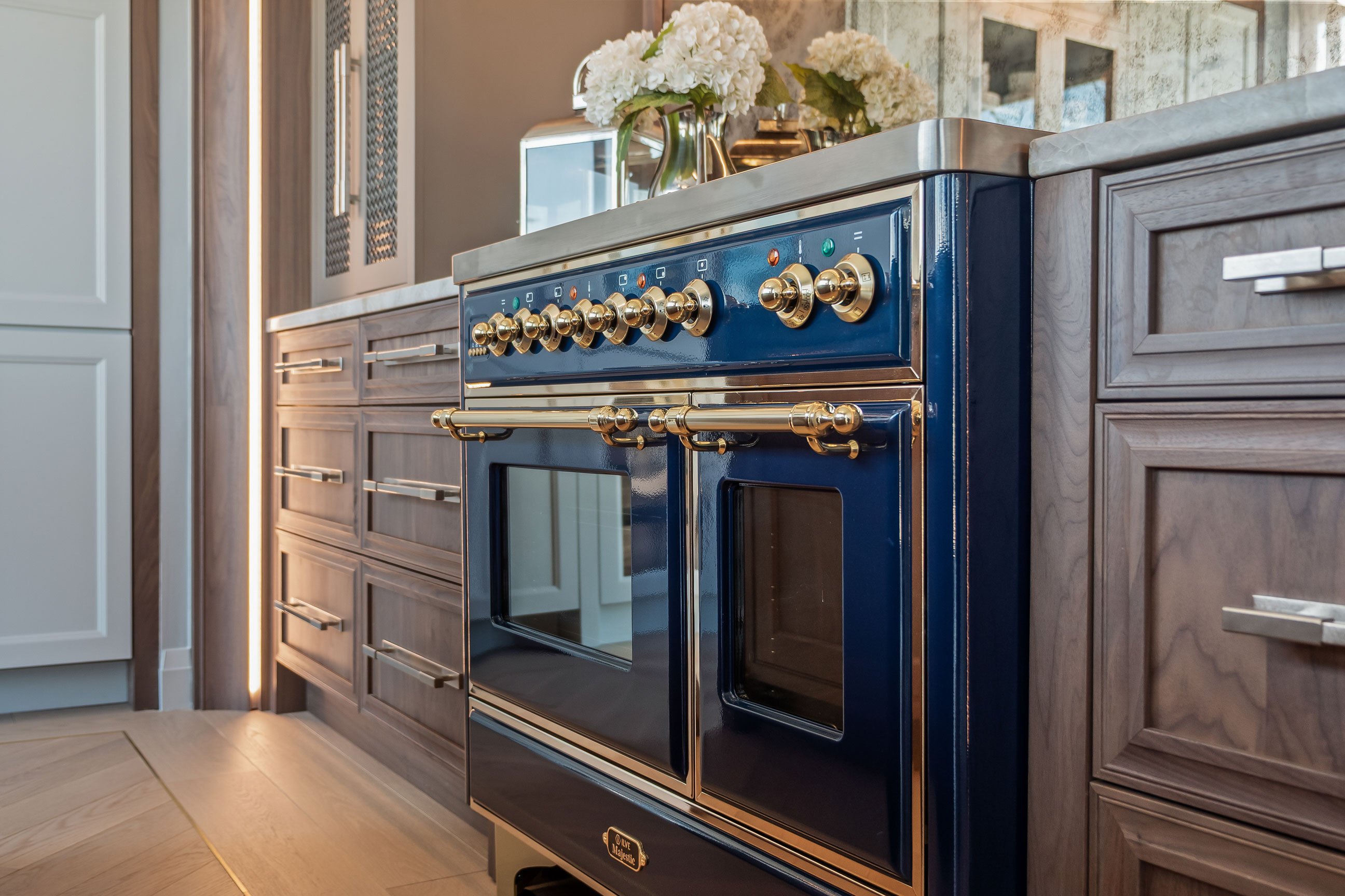 Mix of inset and framed cabinetry in stained and painted finishes flanking a blue range