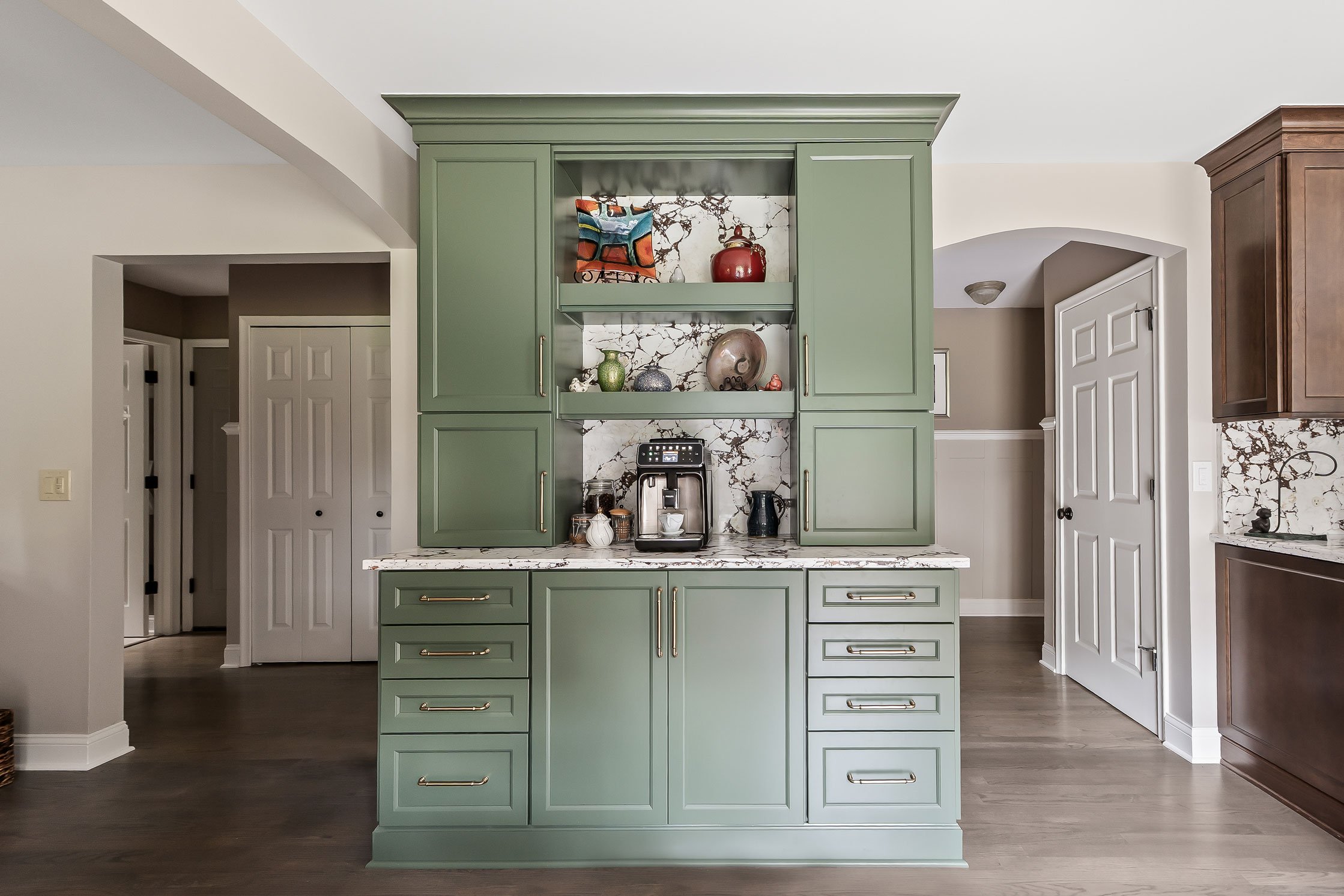 The Evergreen coffee station hutch with open shelving displaying the homeowners' pottery above a built-in espresso machine.