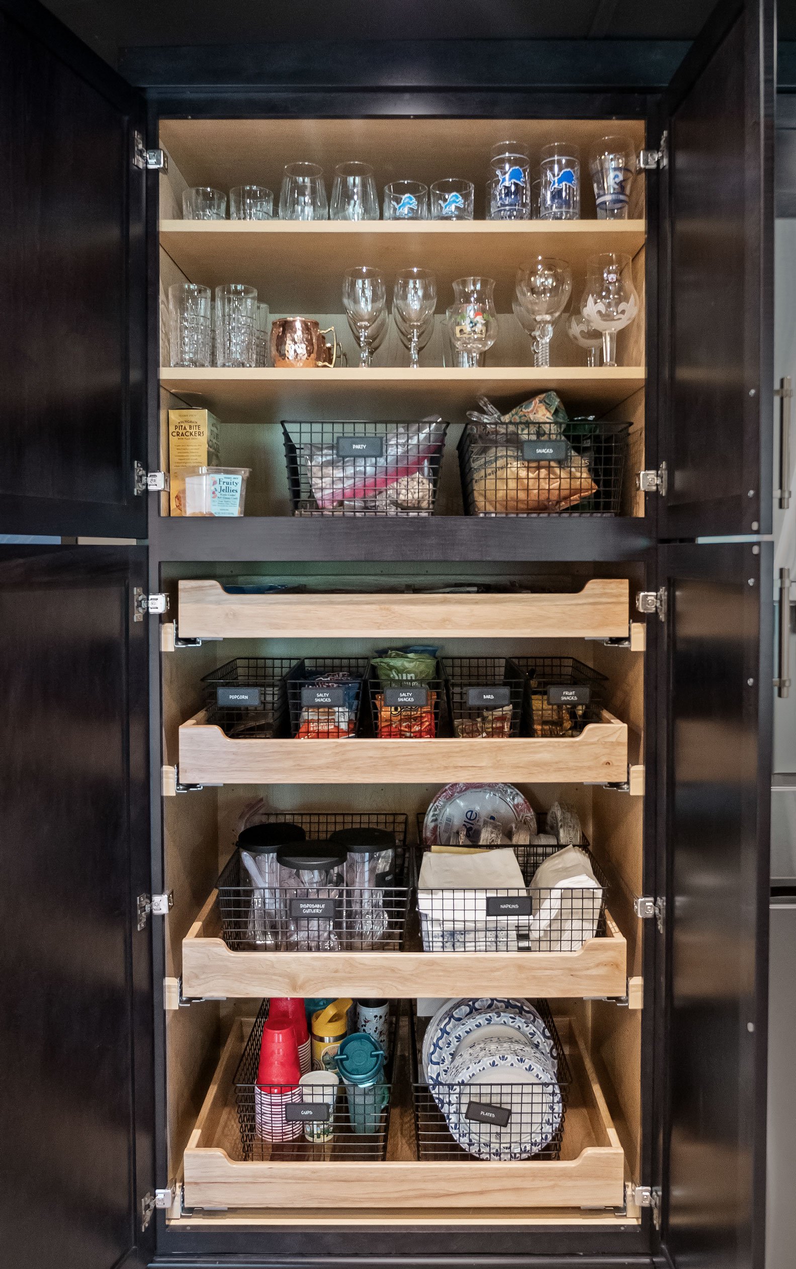 Organized pantry cabinet with pull out drawers and bins