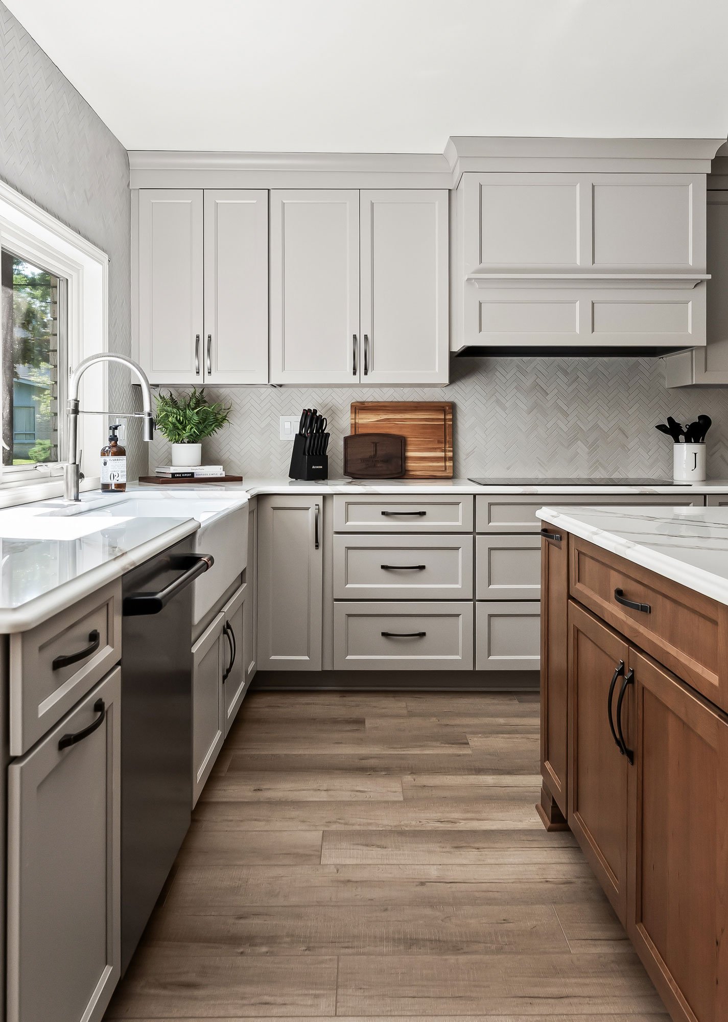 The farmhouse sink and dishwasher along the perimeter counter, next to the cherry-finished kitchen island.