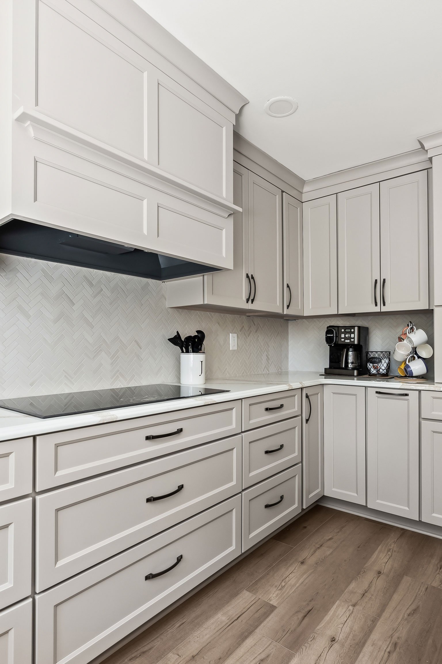 The induction cooktop and a corner coffee station with a built-in coffee maker and mug rack.