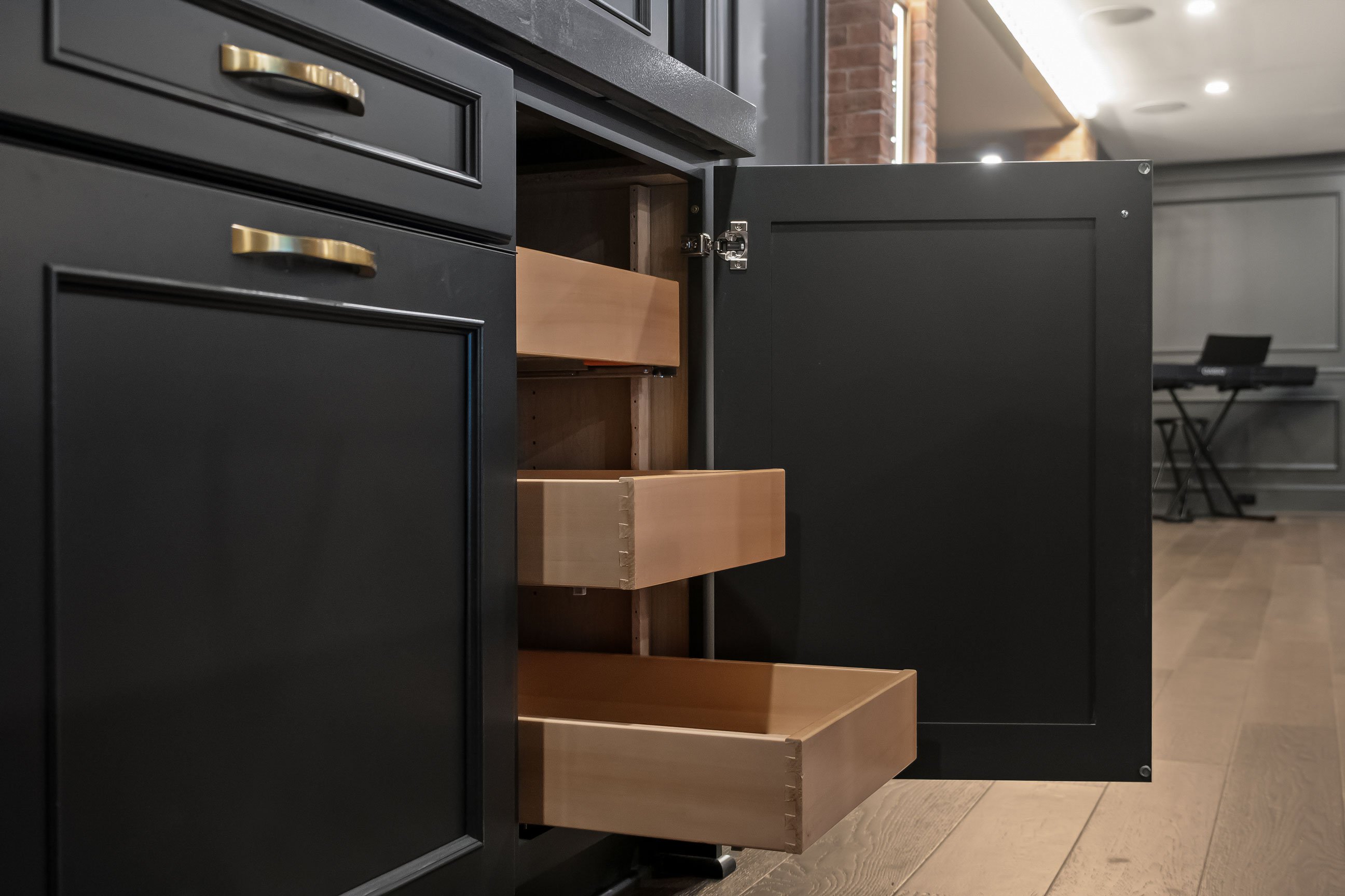 Charcoal cabinets with roll-out drawer storage.
