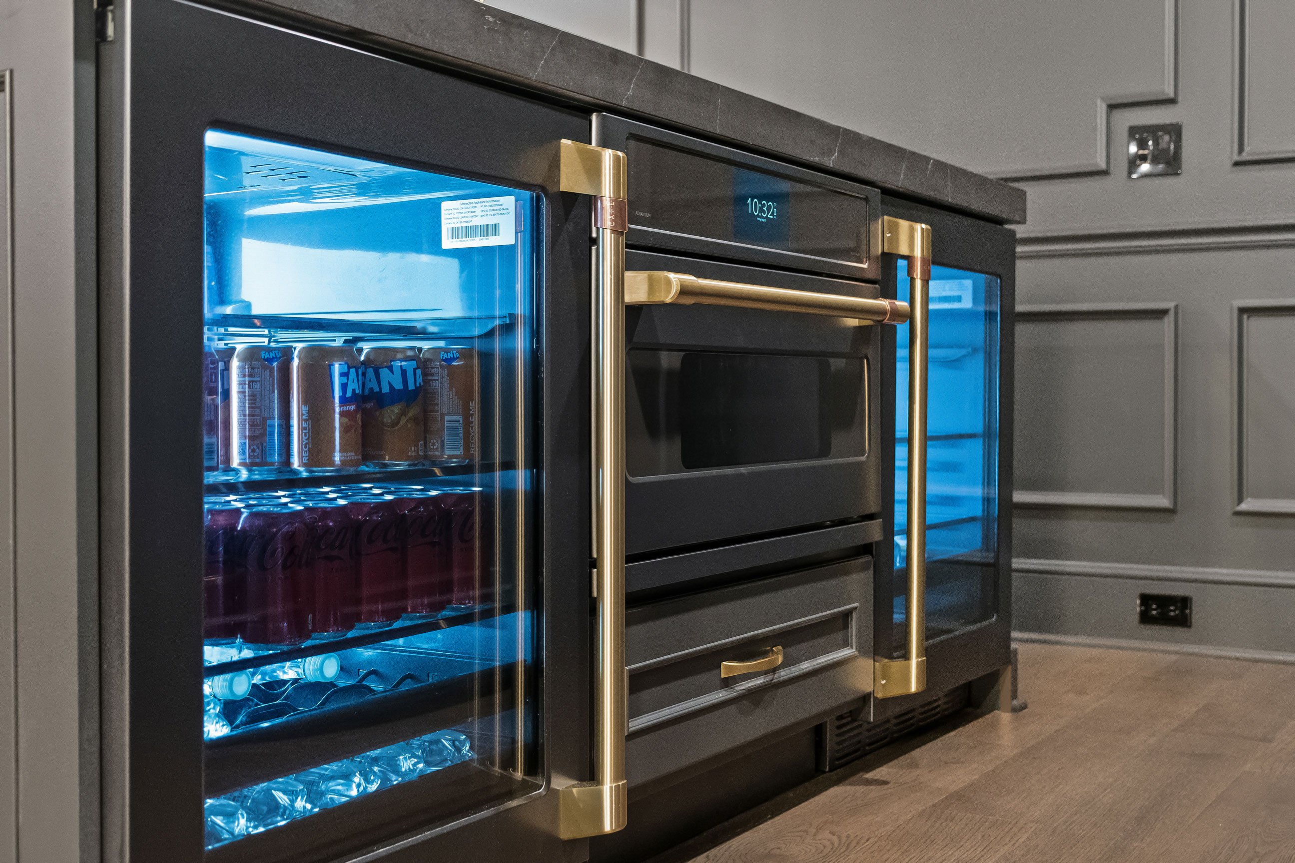 Entertainment bar island with integrated beverage refrigerator, built-in microwave, and charcoal cabinetry.