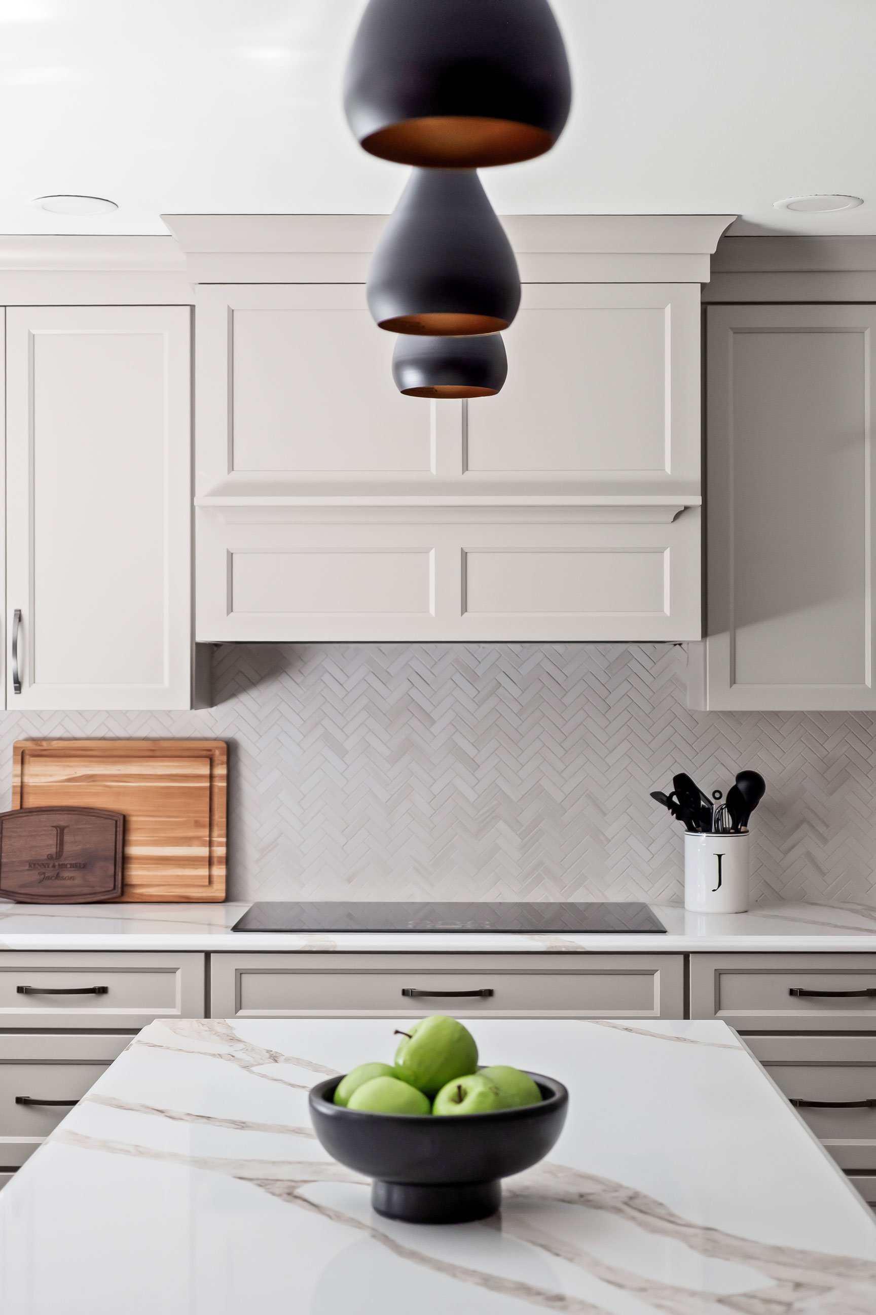 The black teardrop pendant lights above the cooktop.
