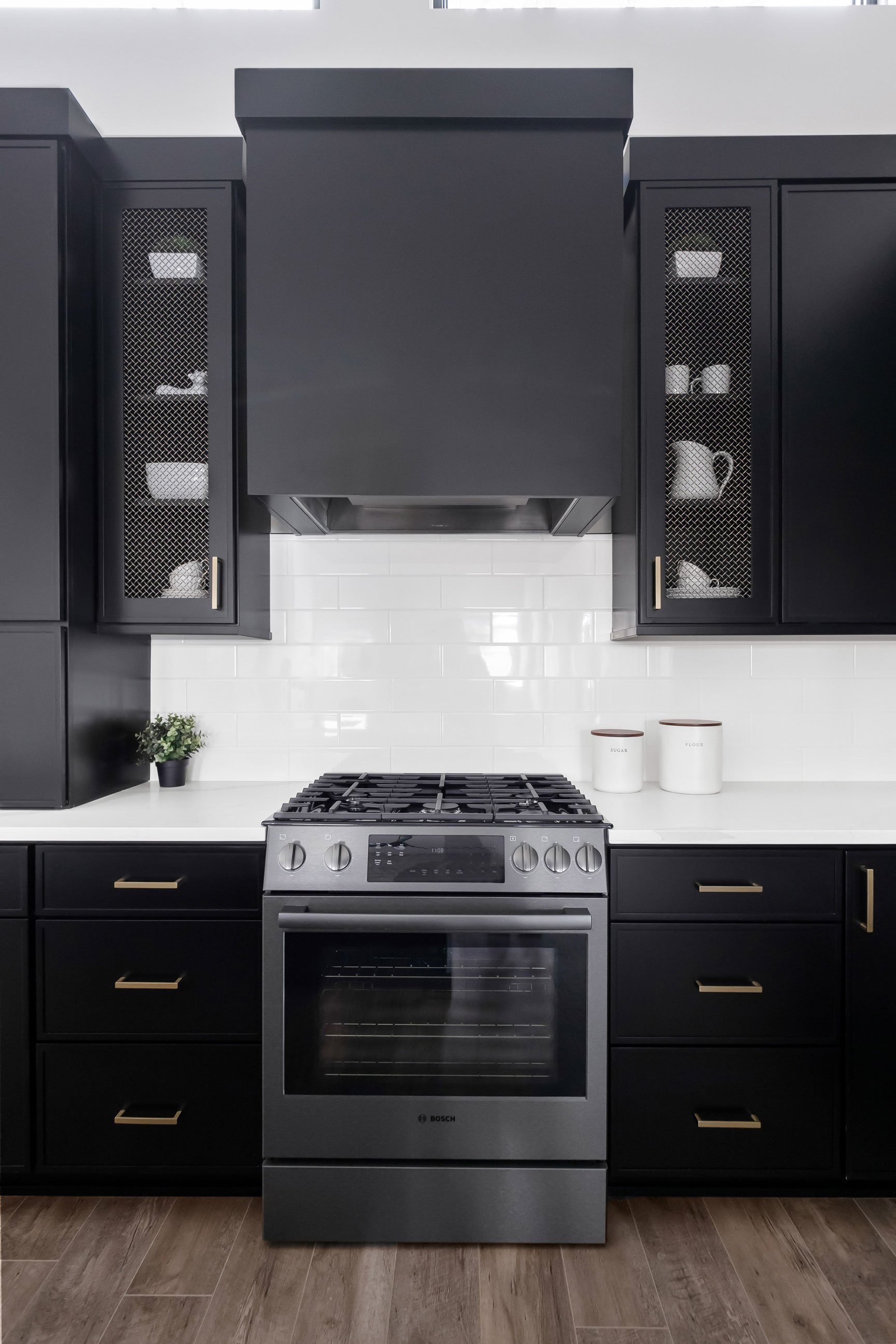 Custom kitchen design with black cabinets and gold mesh accent doors