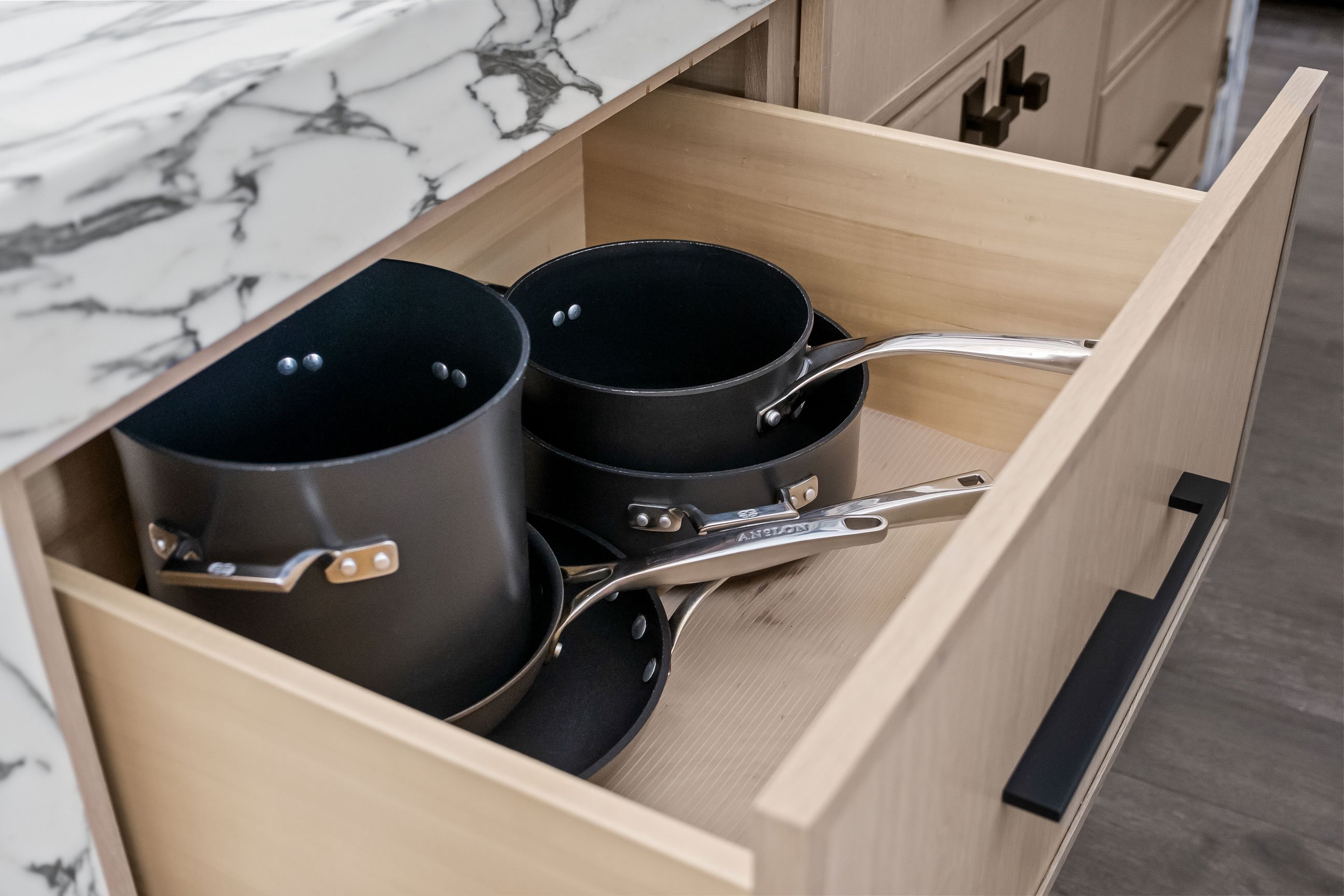 Deep drawer storage for pots and cookware in warm wood cabinetry