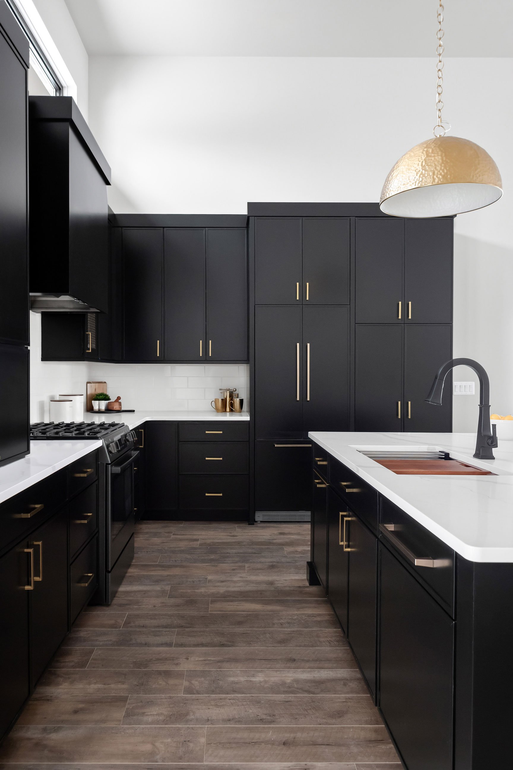 Custom kitchen design with black cabinets and paneled appliances