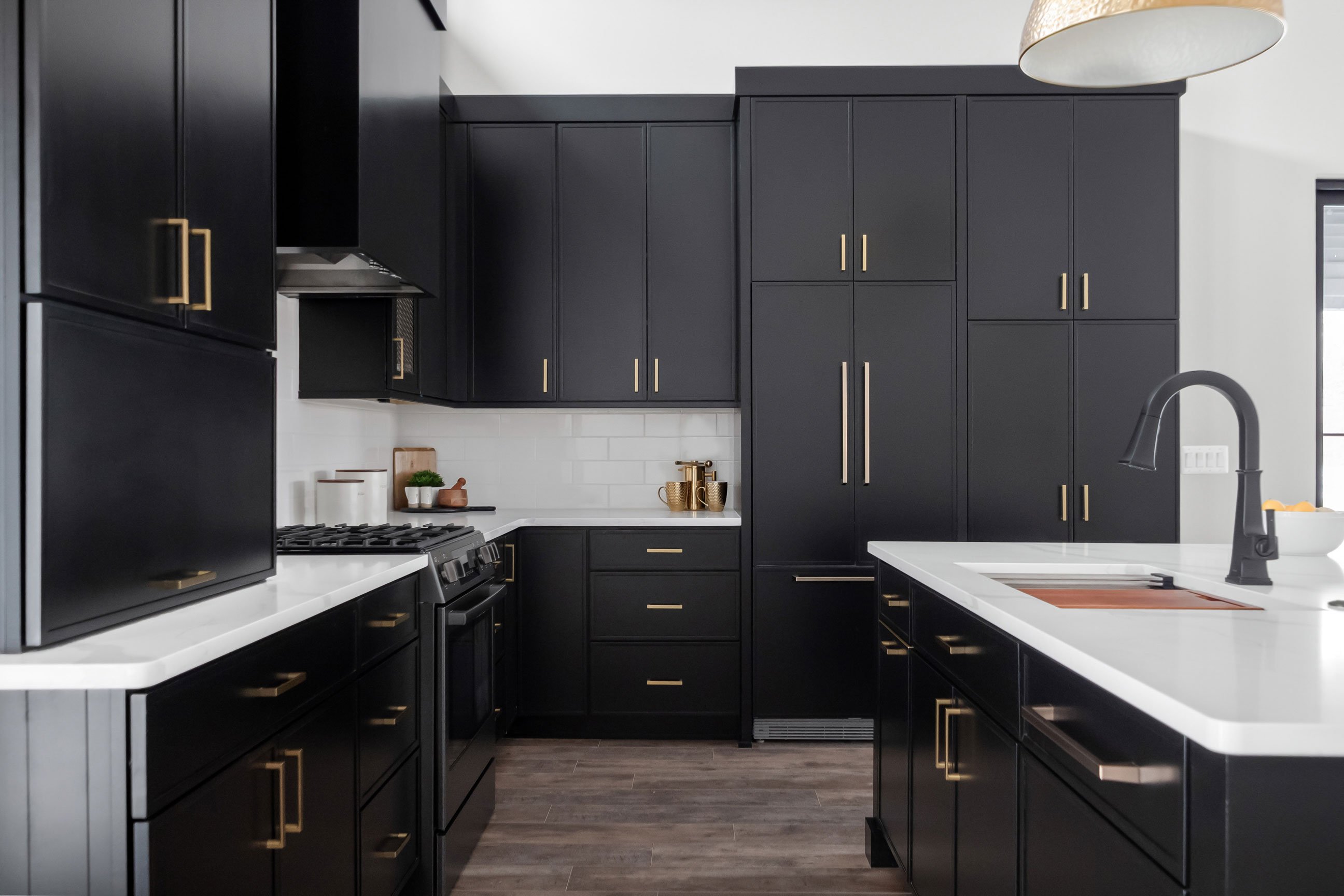 Custom kitchen design with black cabinets and paneled appliances