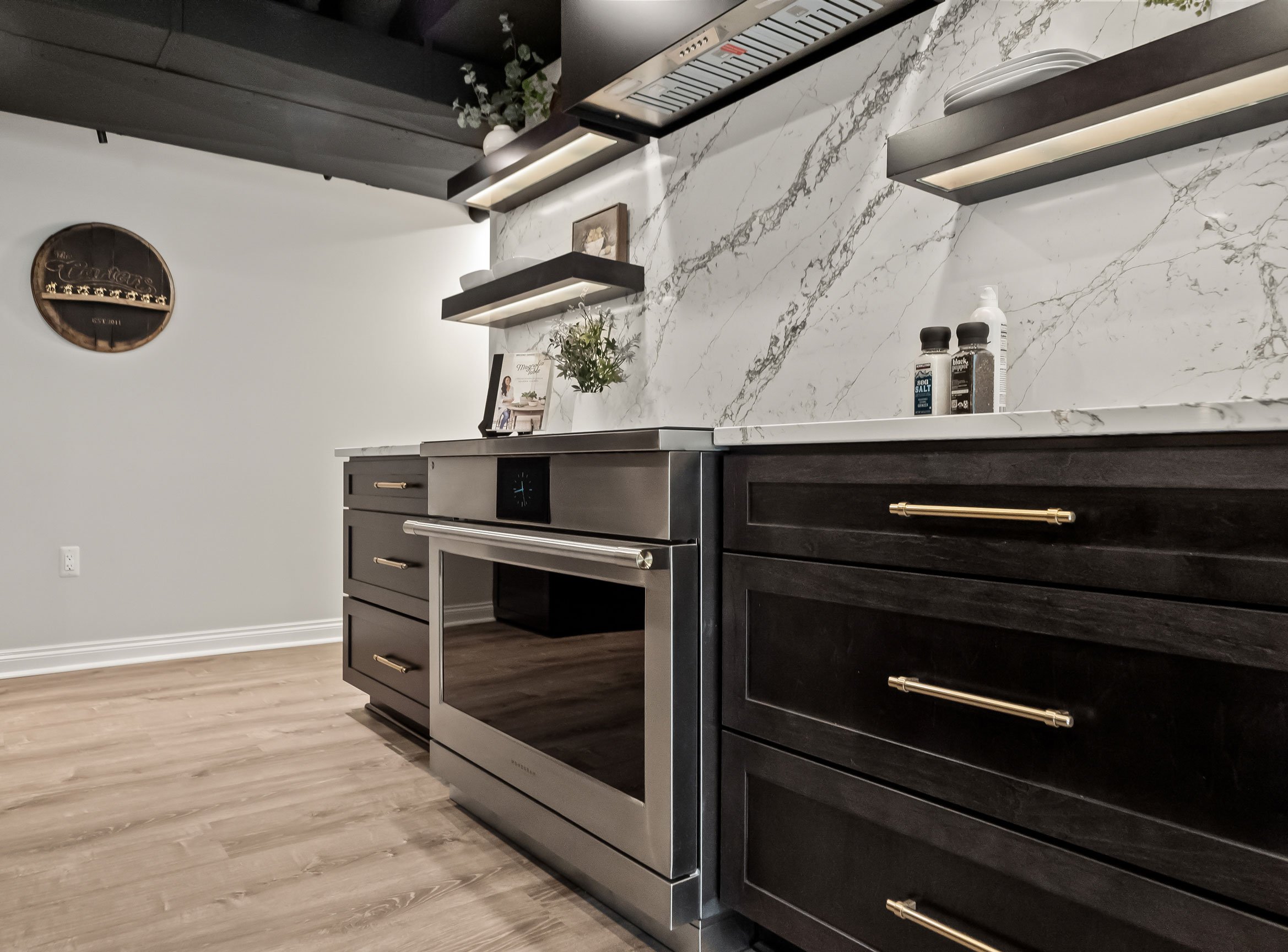 Basement entertainment kitchen with charcoal cabinetry, open shelving, and induction range.