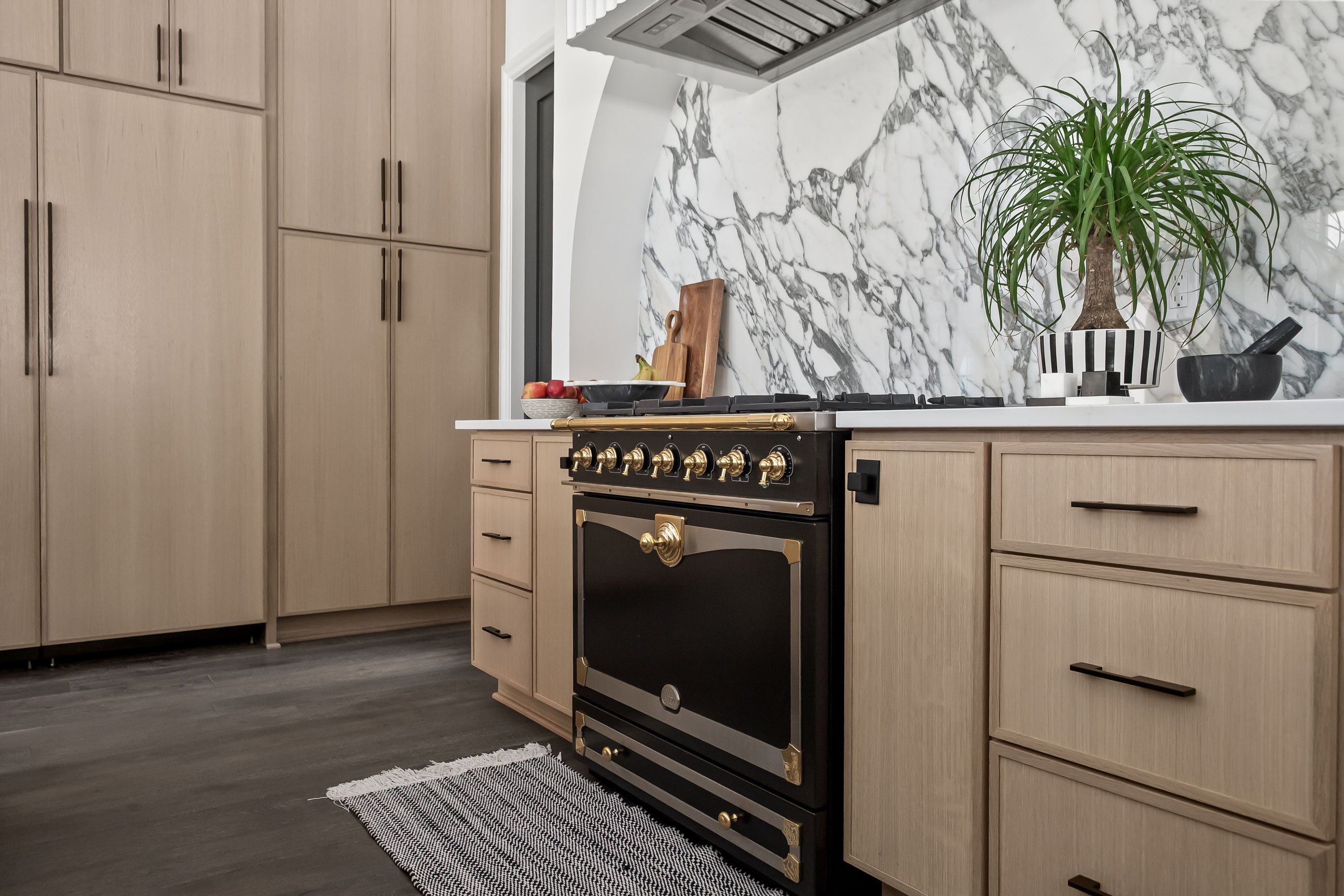 Quartersawn White Oak cabinetry and paneled appliances with dramatic backsplash over black range