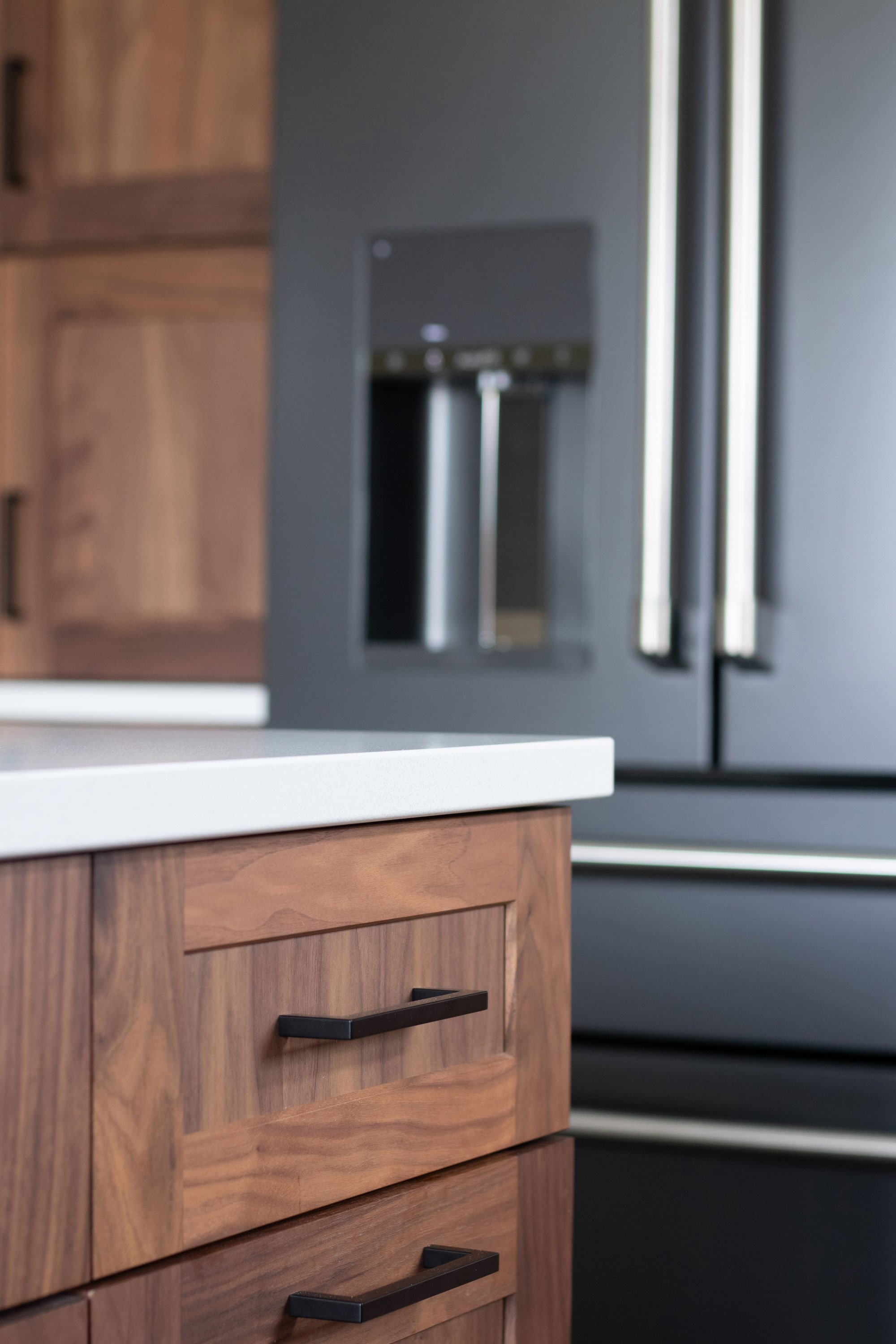 Inspira Cabinetry in natural walnut with matte black hardware and appliances