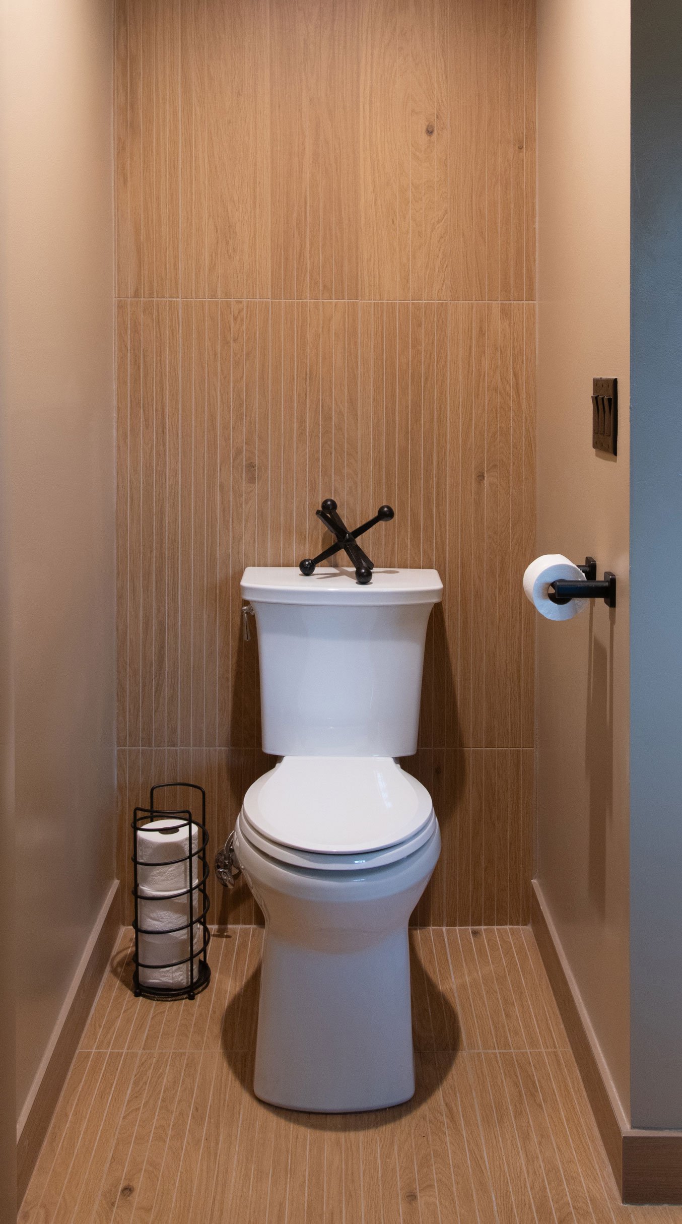 Toilet alcove with warm wood-look tile wall detail