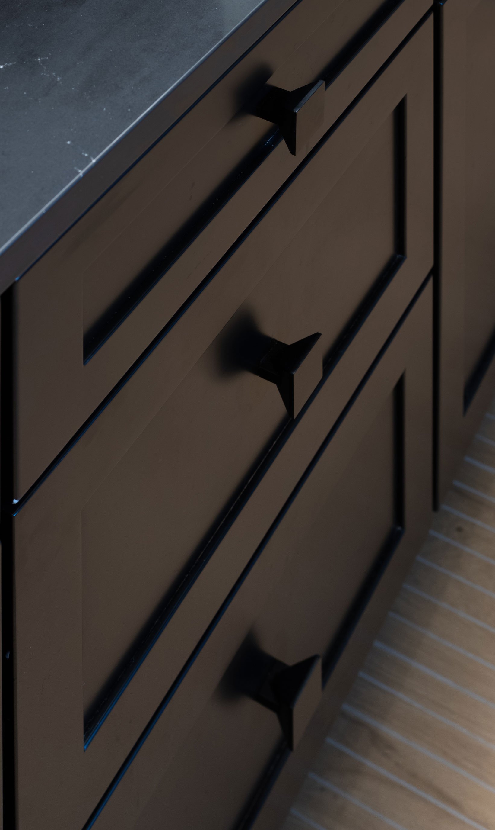 Black cabinet hardware detail on shaker drawers